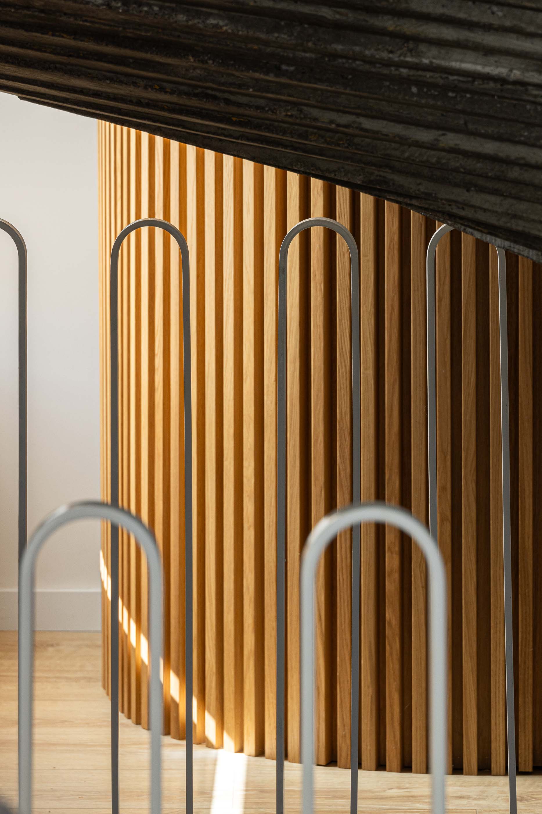 Escada: Pormenor da escada com revestimento em madeira e guarda em metal cinzento. — Casa Arco arquitetura Tiago Sousa Arquitecto em Paredes de Coura