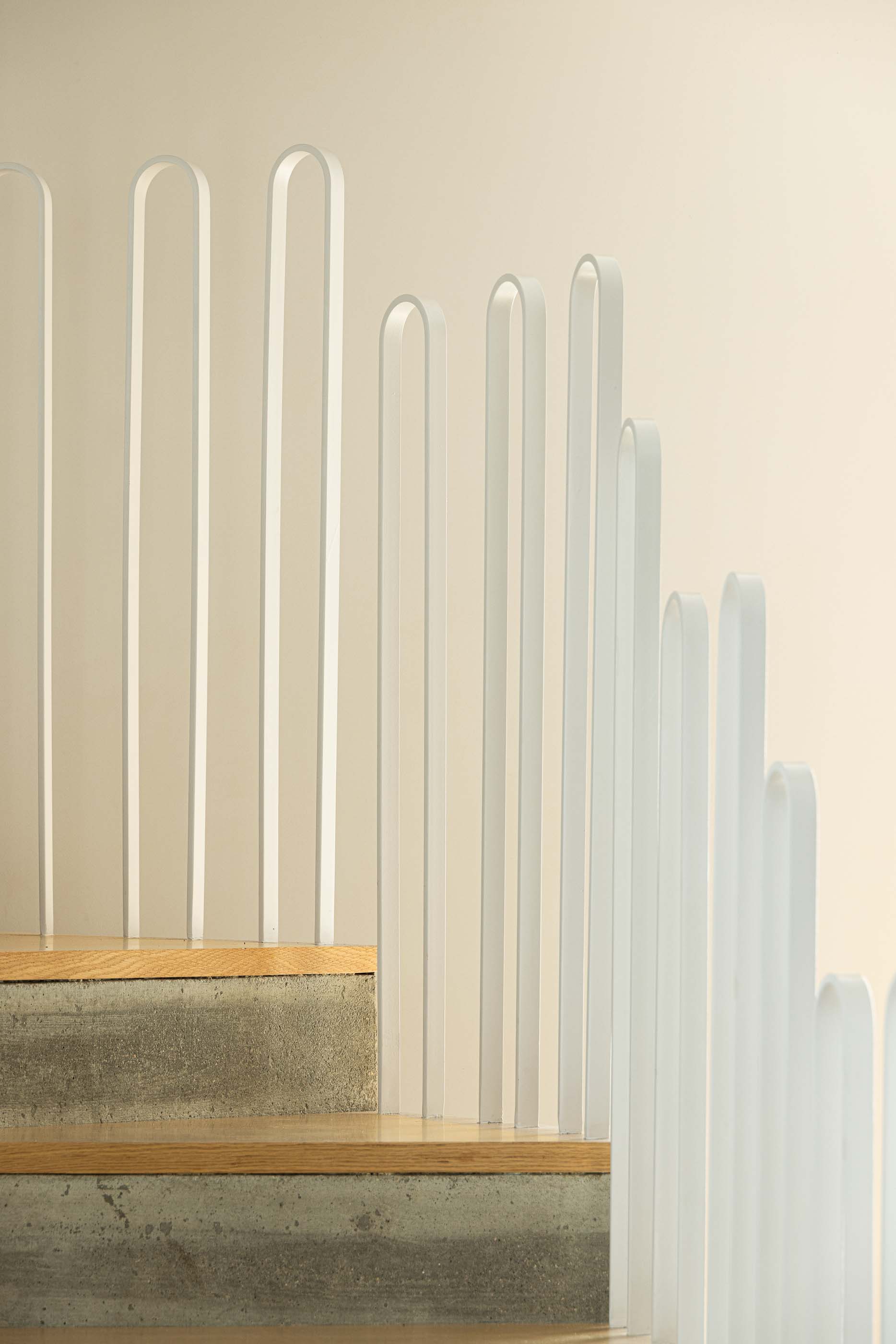 Escada: Detalhe da escada em betão e madeira com guarda em metal branco. — Casa Arco arquitetura Tiago Sousa Arquitecto em Paredes de Coura
