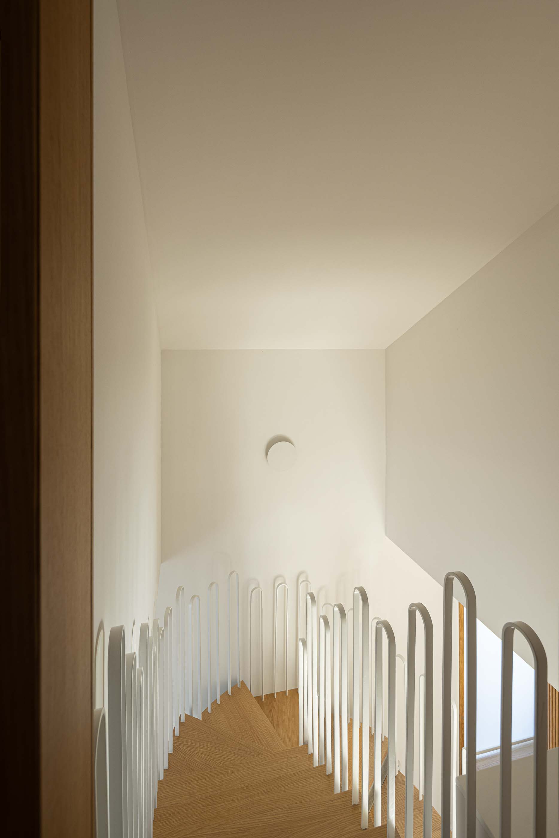 Escada: Vista superior da escada com guarda em metal branco e degraus em madeira. — Casa Arco arquitetura Tiago Sousa Arquitecto em Paredes de Coura