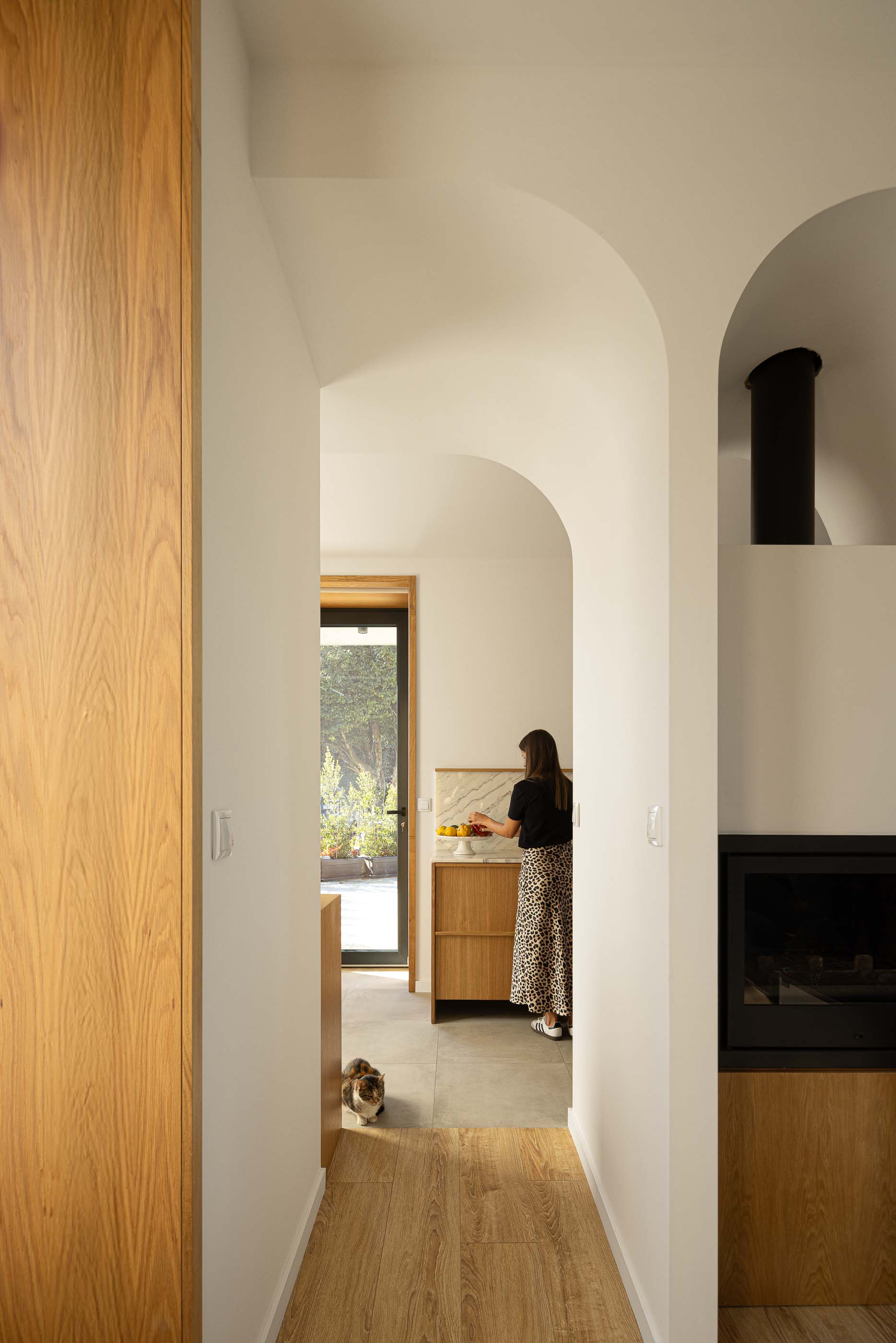 Corredor: Vista do corredor com arcos para a cozinha e sala de estar. — Casa Arco arquitetura Tiago Sousa Arquitecto em Paredes de Coura