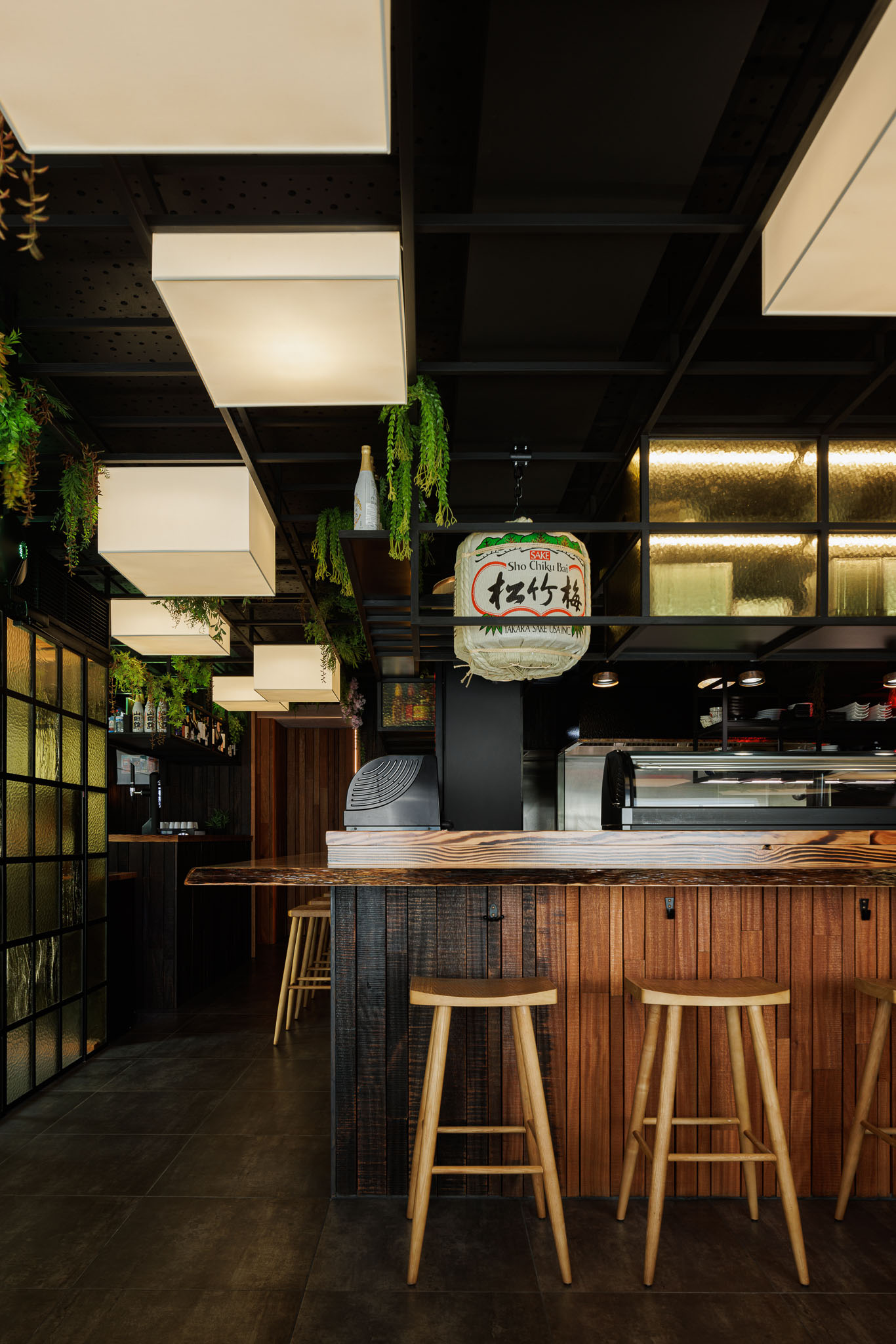 Balcão: Balcão em madeira rústica, bancos altos, candeeiros quadrados e decoração japonesa. — Restaurante Izakaya Matsuri arquitetura Ferreira Arquitetos em Aveiro