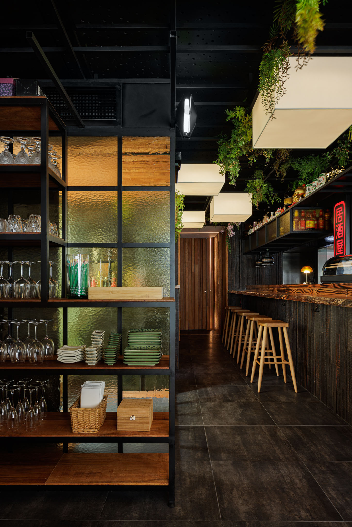Corredor: Estantes de madeira e metal, balcão, candeeiros quadrados e divisória de vidro texturado. — Restaurante Izakaya Matsuri arquitetura Ferreira Arquitetos em Aveiro