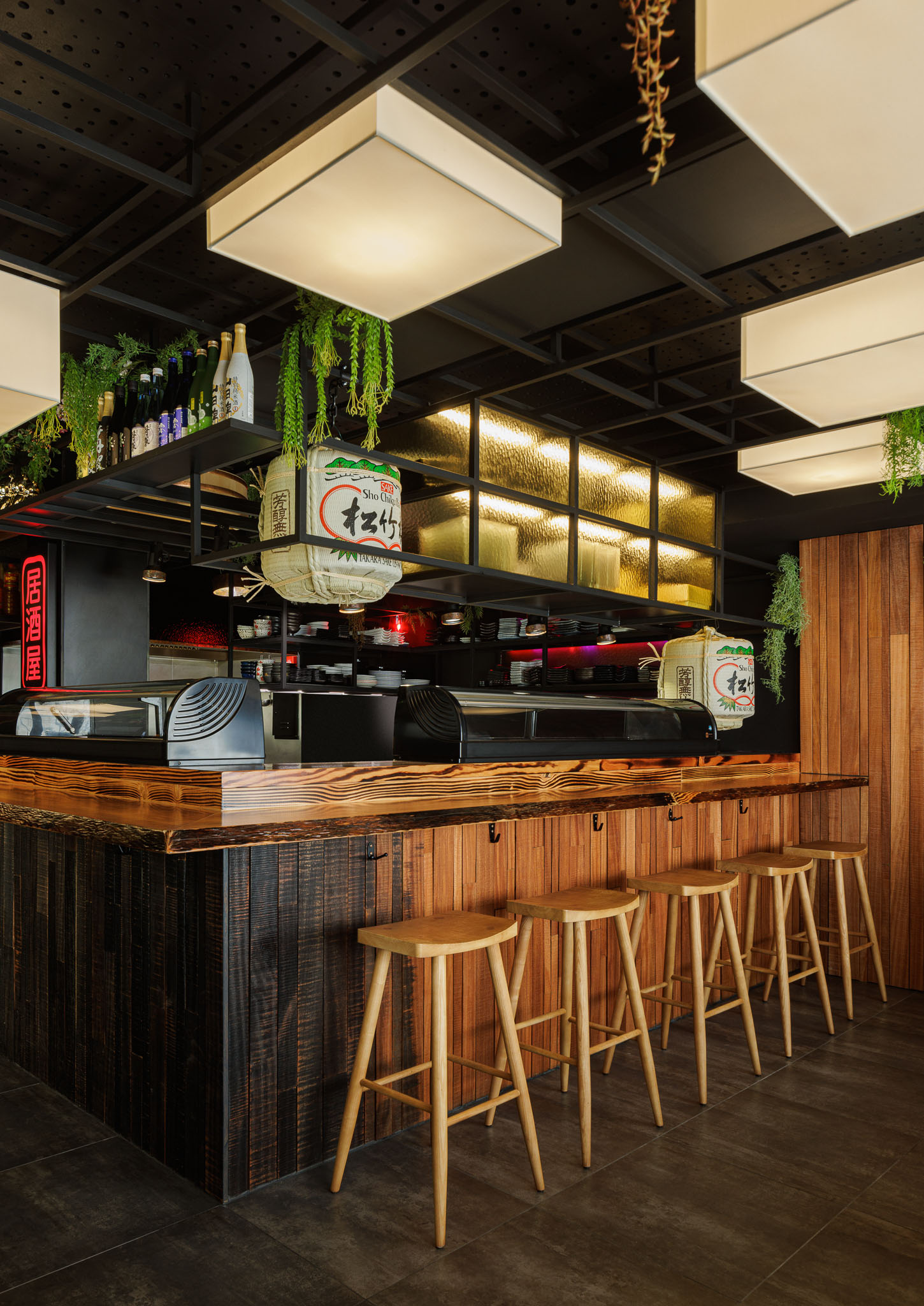 Balcão: Balcão em madeira rústica, bancos altos, prateleiras com garrafas e decoração japonesa. — Restaurante Izakaya Matsuri arquitetura Ferreira Arquitetos em Aveiro