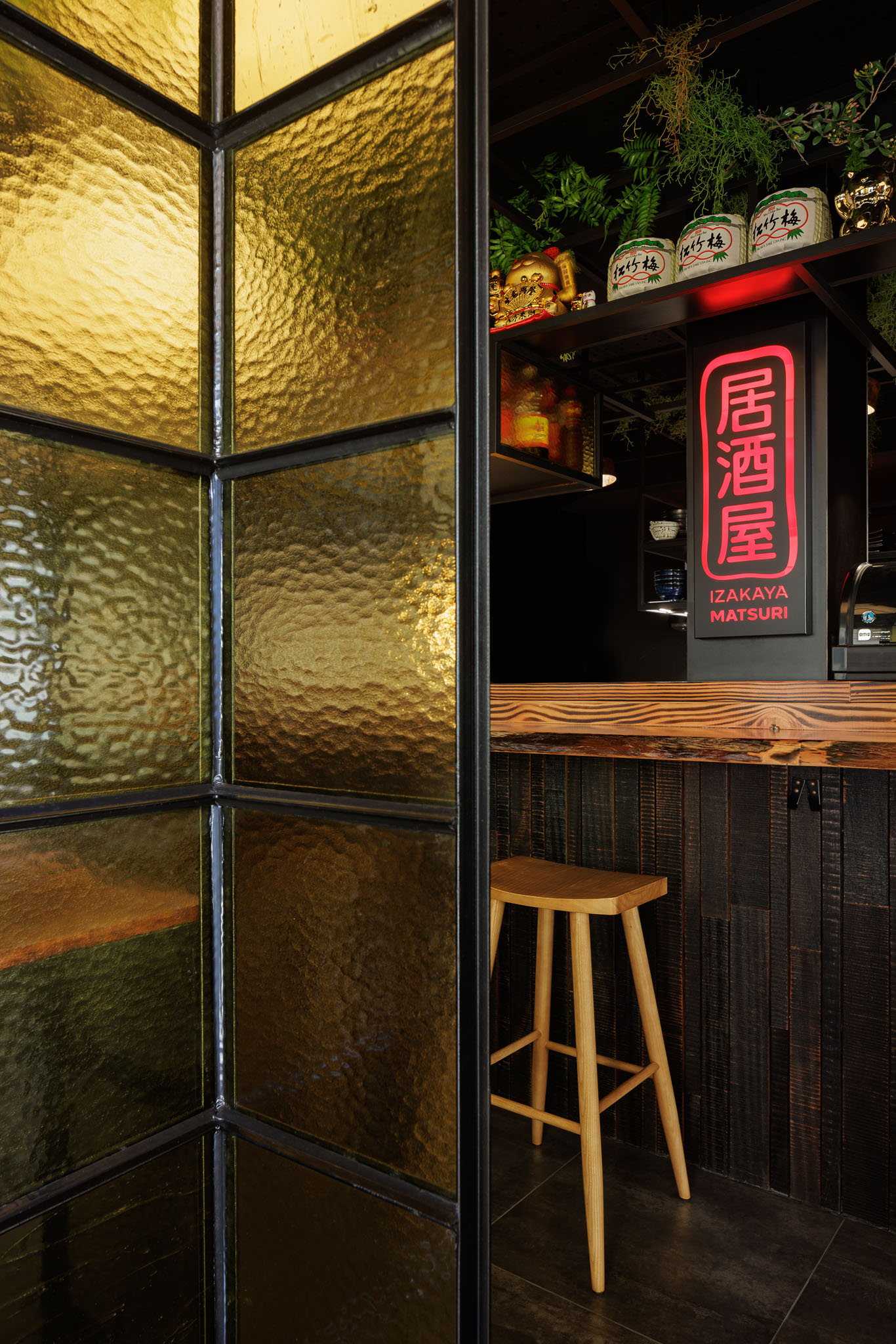 Divisória: Detalhe da divisória em vidro texturado amarelo e estrutura metálica preta. — Restaurante Izakaya Matsuri arquitetura Ferreira Arquitetos em Aveiro