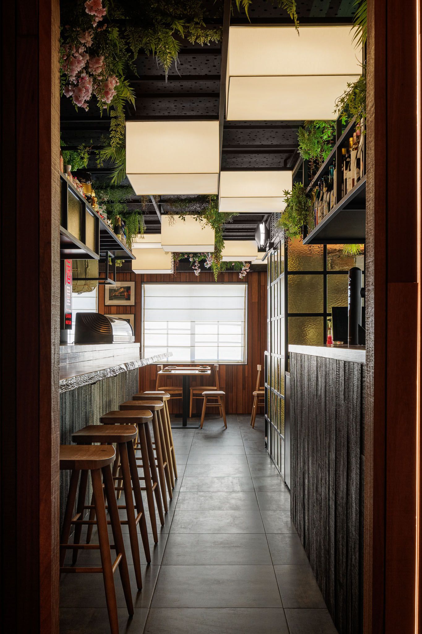 Corredor: Vista do corredor com balcão, bancos altos, divisória de vidro e iluminação. — Restaurante Izakaya Matsuri arquitetura Ferreira Arquitetos em Aveiro