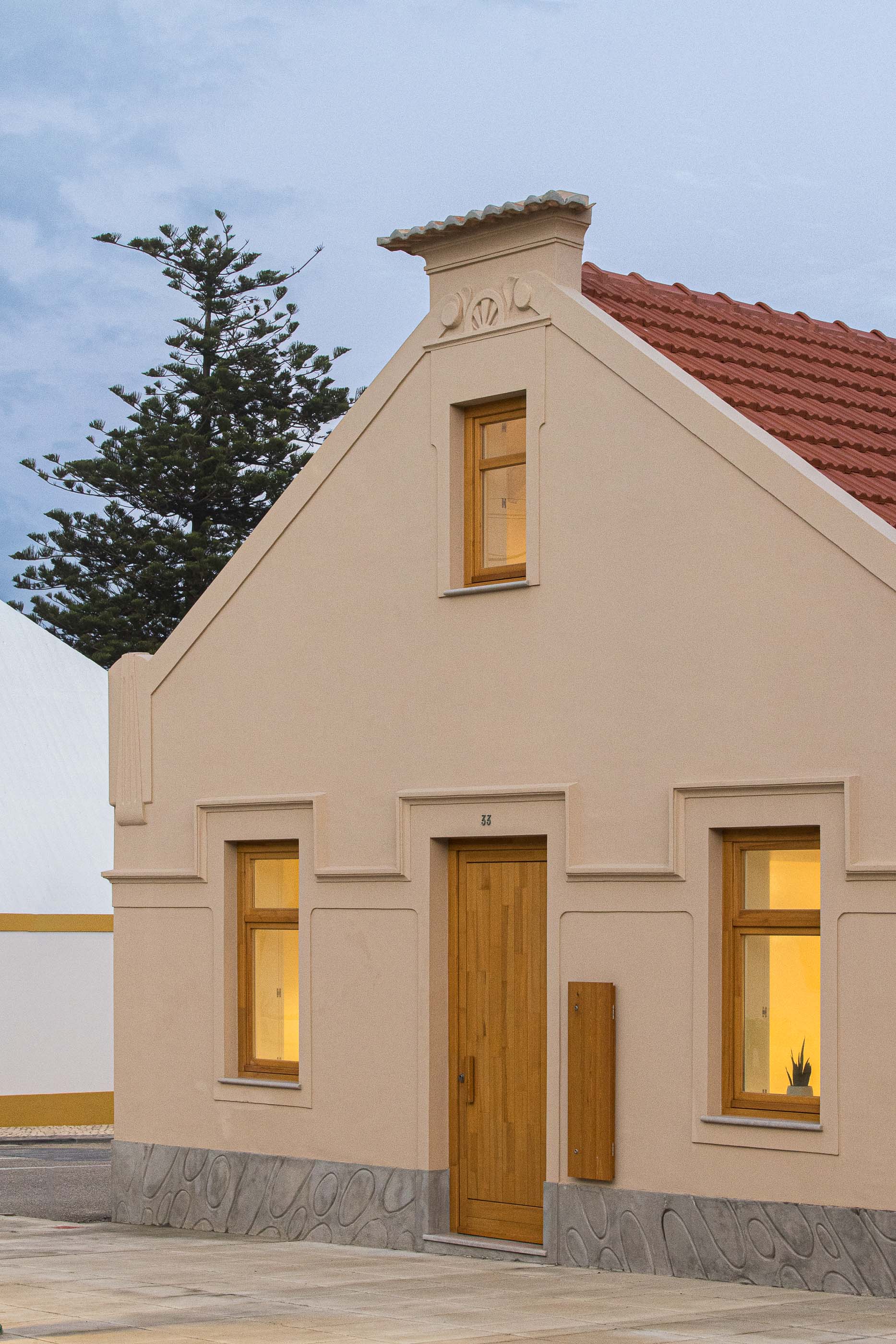 Exterior: Fachada da casa com porta de madeira clara, janelas com molduras em madeira e detalhes clássicos. — Casa Clara arquitetura M2Senos Arquitectos em Ílhavo