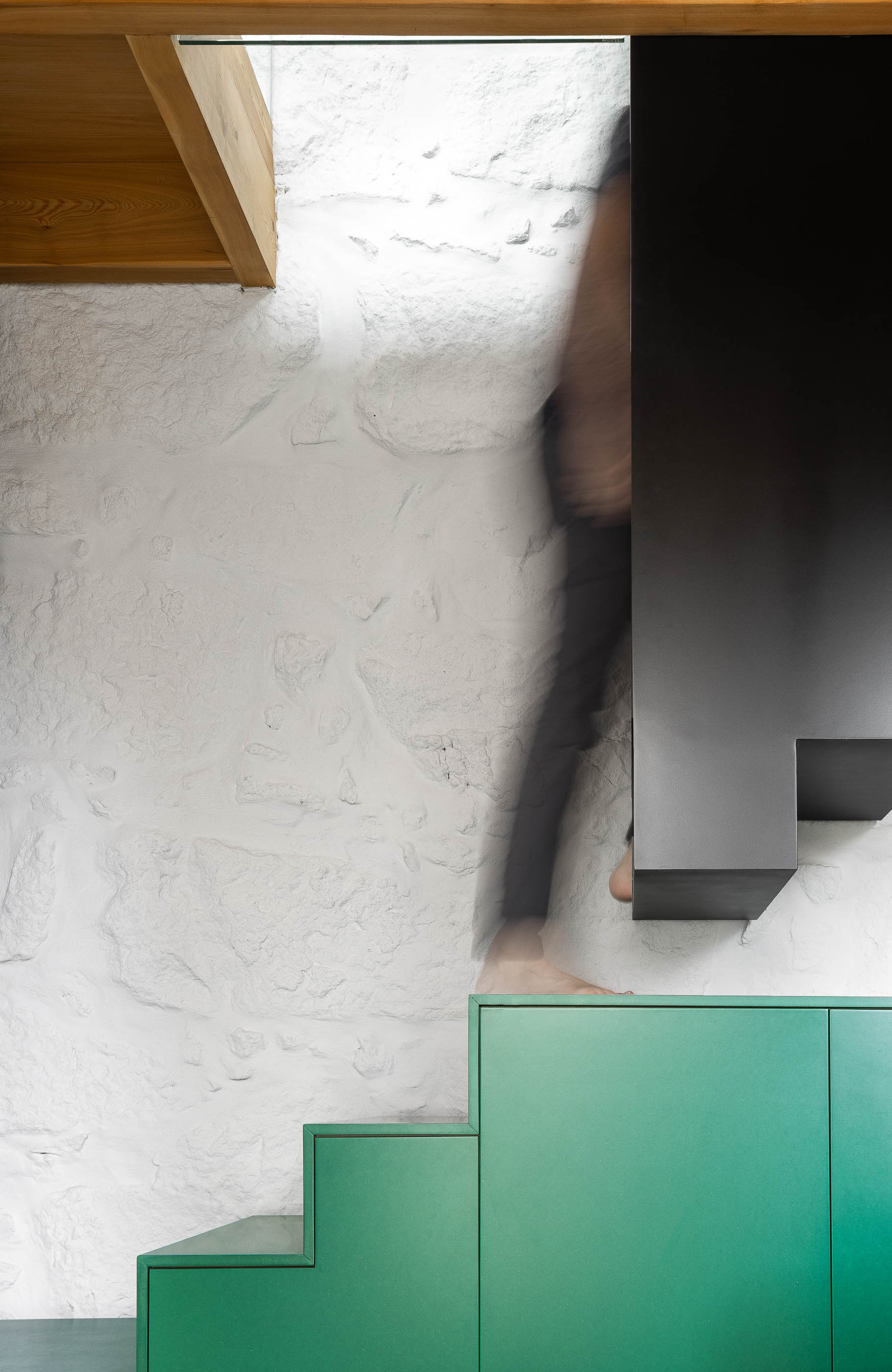 Sala de estar/Escada: Degraus verdes, escada preta e parede em pedra branca. Teto em madeira. — Casa Covelo arquitetura spaceworkers em Porto