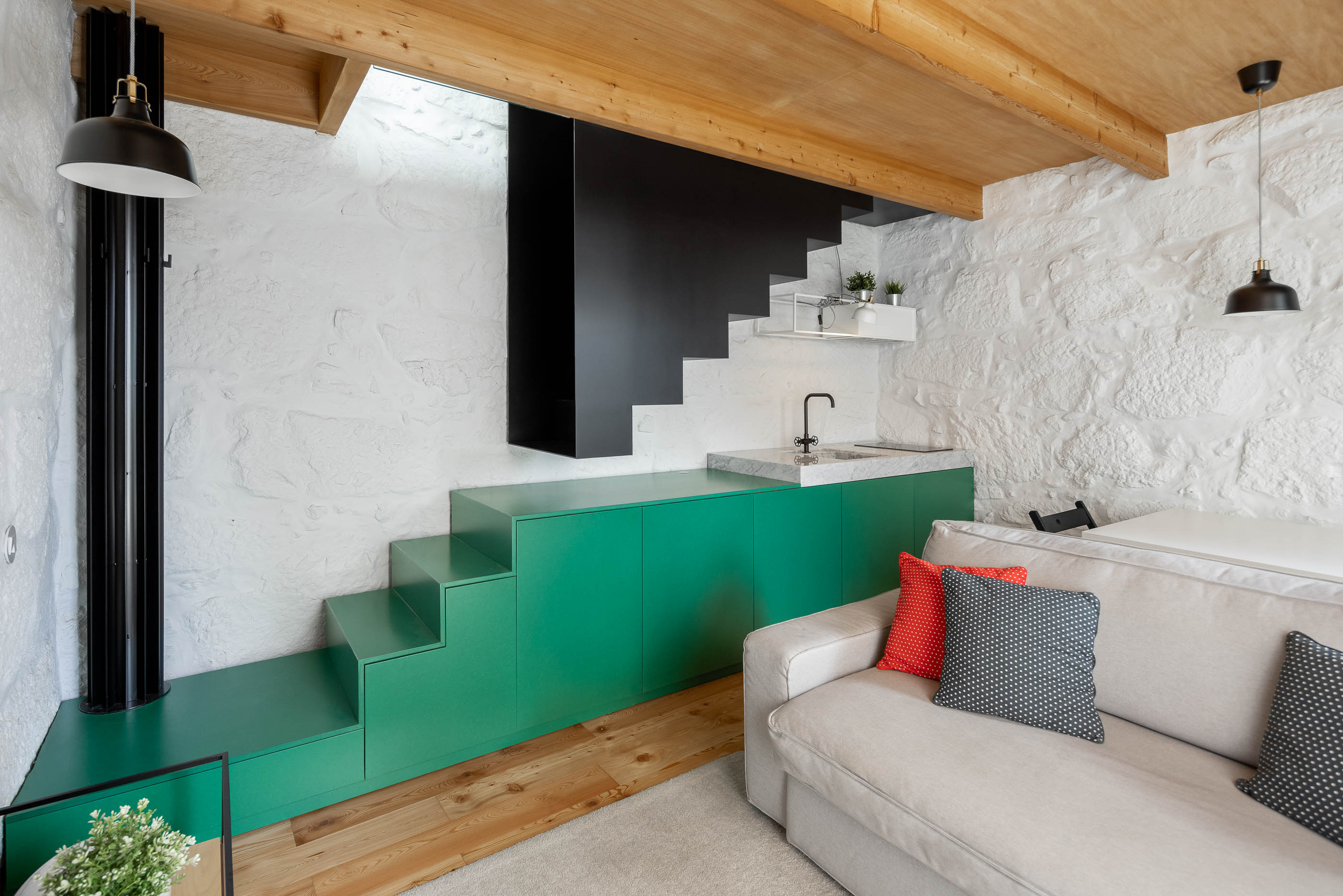 Sala de estar/Escada: Escada preta, bancada verde, parede em pedra branca e teto em madeira. — Casa Covelo arquitetura spaceworkers em Porto