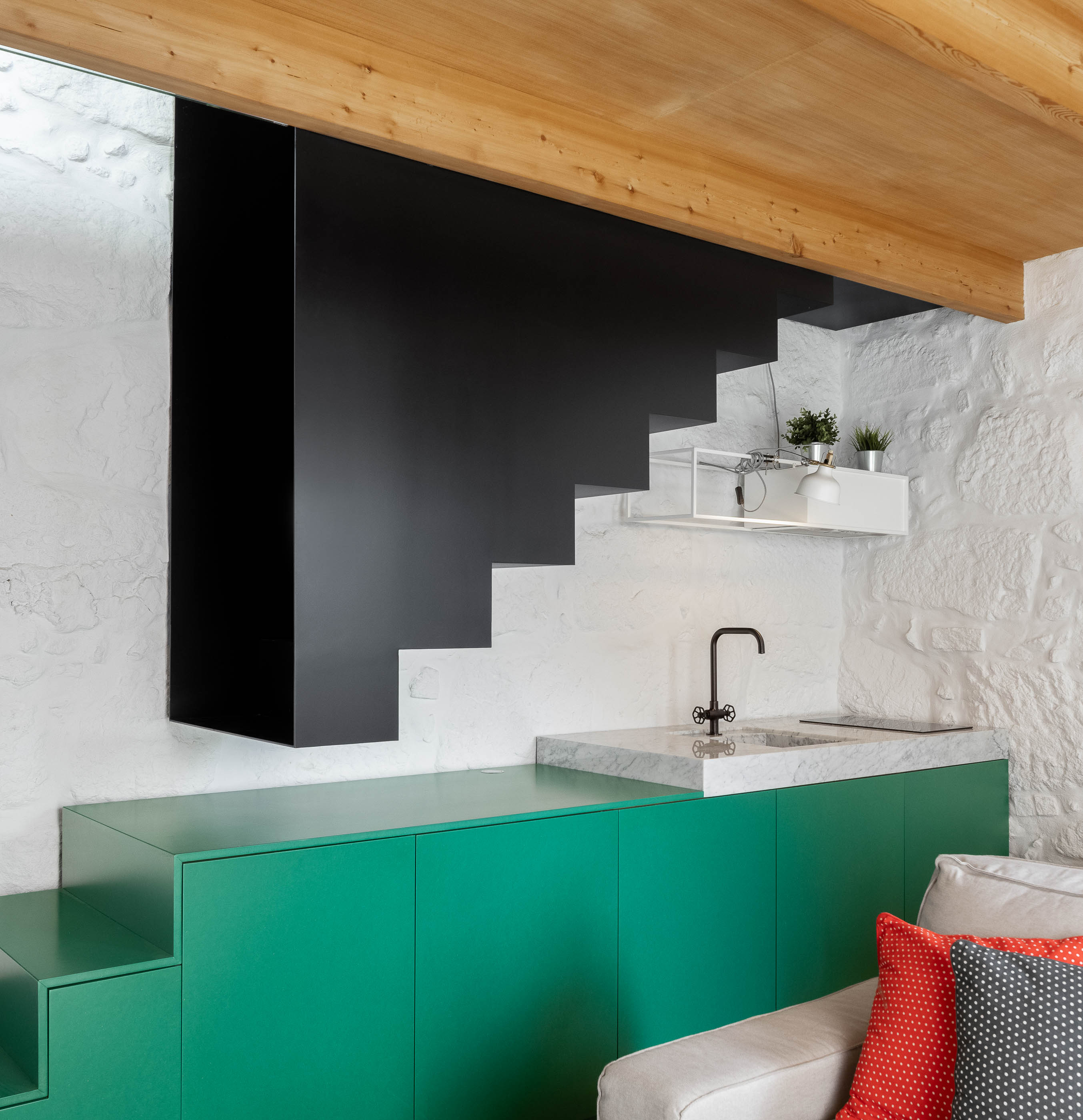 Sala de estar/Escada: Escada preta, bancada verde, parede em pedra branca e teto em madeira. — Casa Covelo arquitetura spaceworkers em Porto