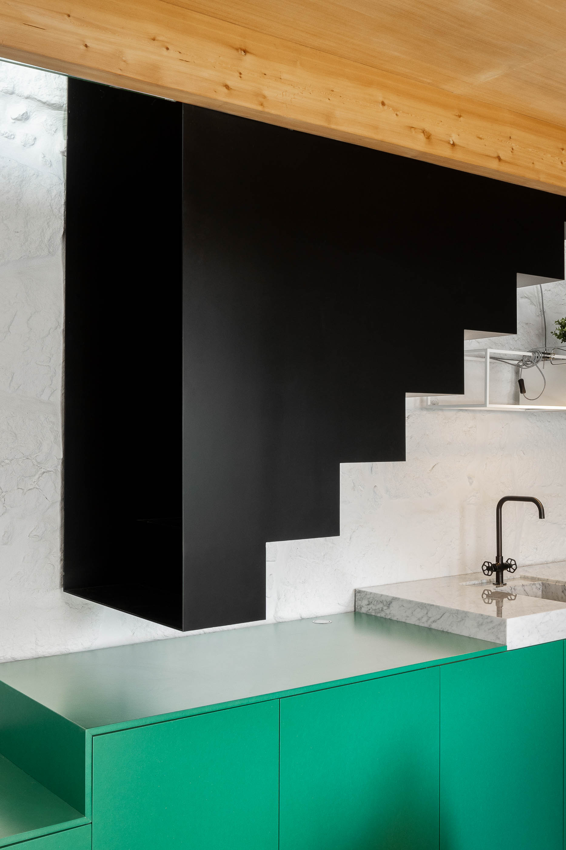 Sala de estar: Sofá cinzento, janela com portadas verdes, parede em pedra branca e teto em madeira. — Casa Covelo arquitetura spaceworkers em Porto