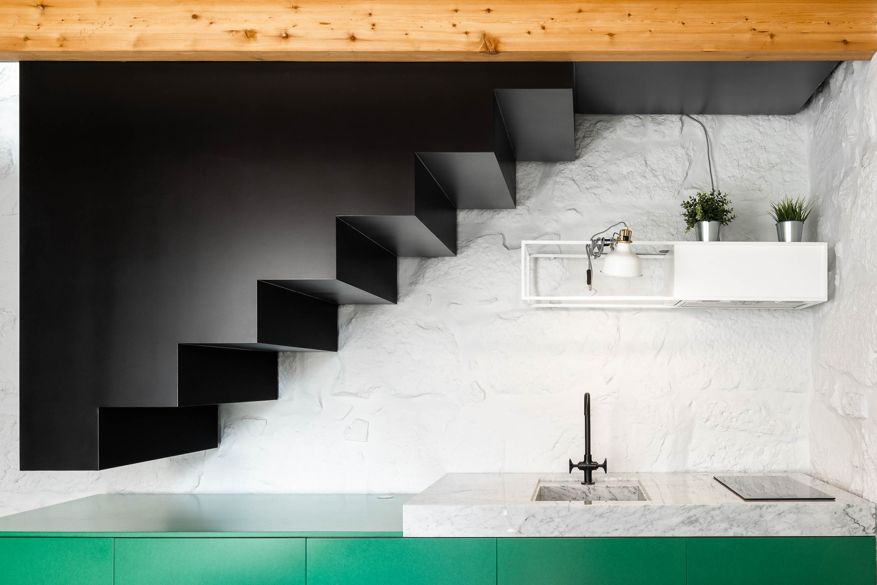 Escada: Detalhe da escada preta flutuante e parede em pedra branca texturizada. — Casa Covelo arquitetura spaceworkers em Porto