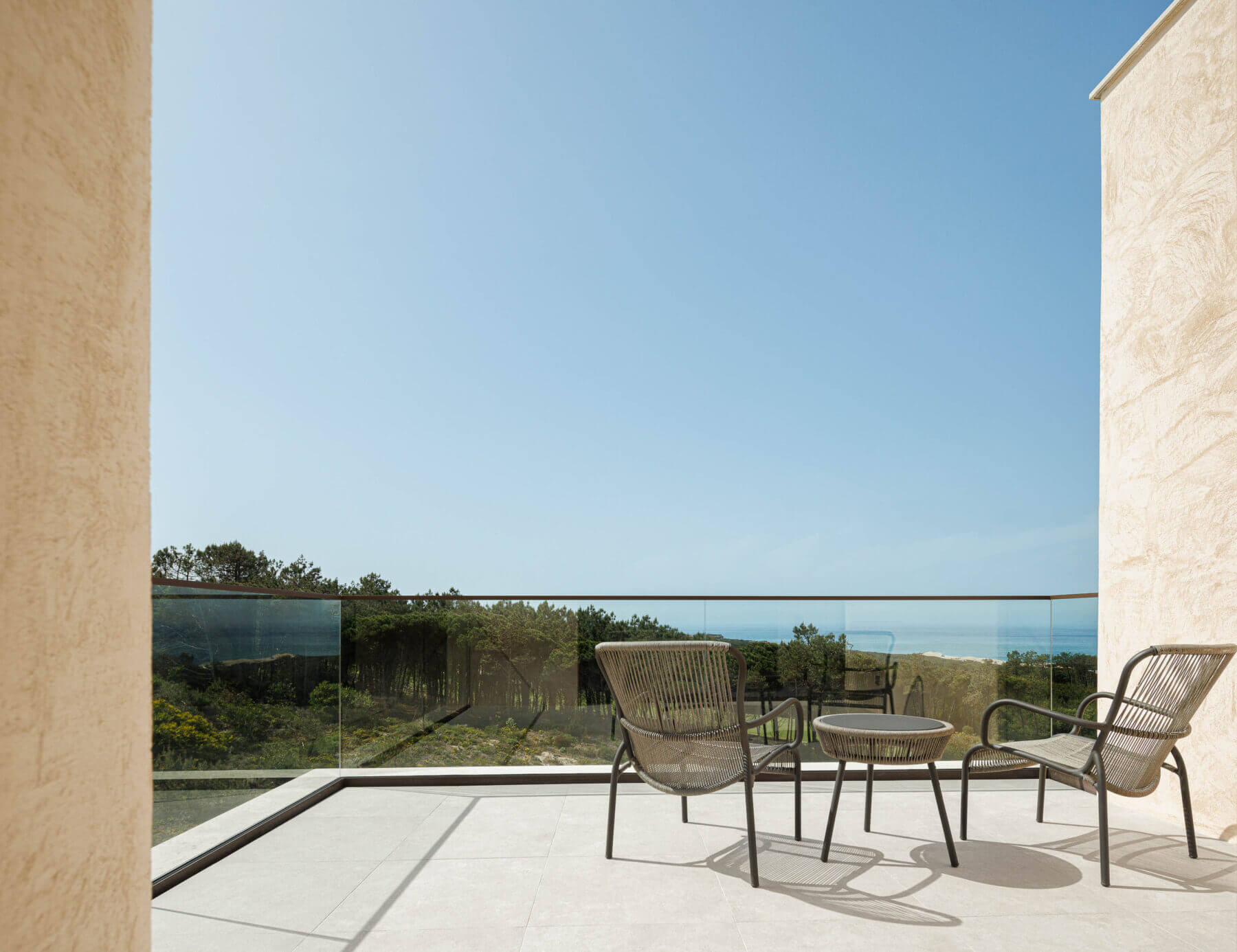 Varanda: Cadeiras em corda e mesa de apoio com vista panorâmica. — Parada das Estrelas arquitetura Solano Soto Architecture Studio em Óbidos