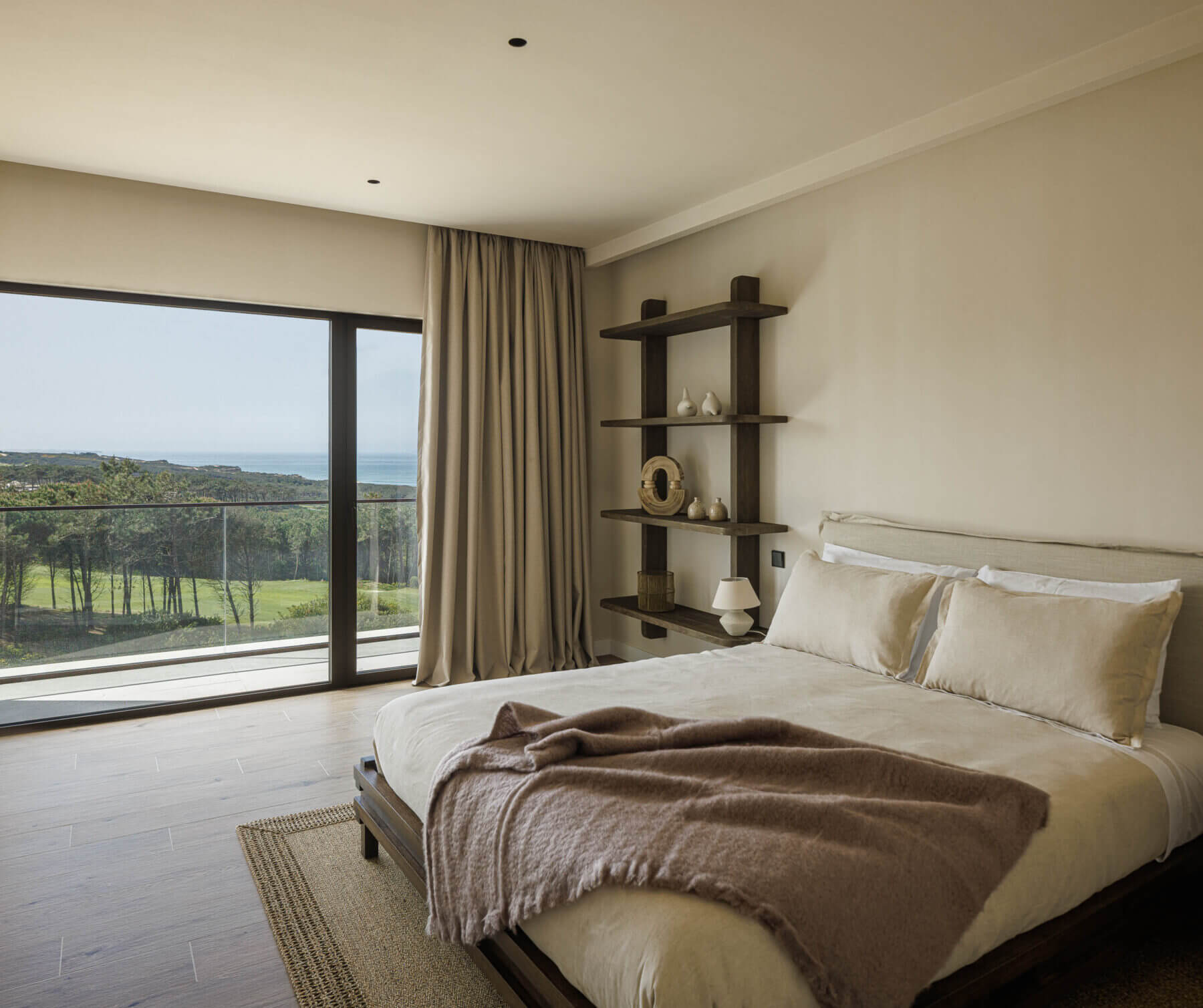 Quarto: Cama de casal com vista para a paisagem e estantes de madeira na parede. — Parada das Estrelas arquitetura Solano Soto Architecture Studio em Óbidos