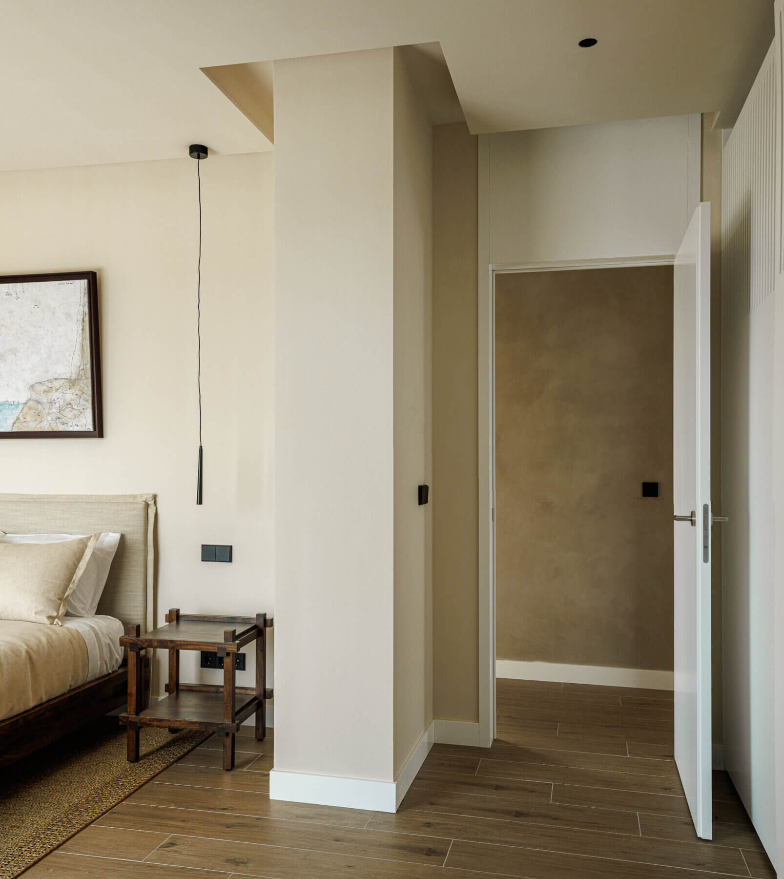 Quarto: Cama de casal, mesa de cabeceira em madeira e porta para a casa de banho. — Parada das Estrelas arquitetura Solano Soto Architecture Studio em Óbidos