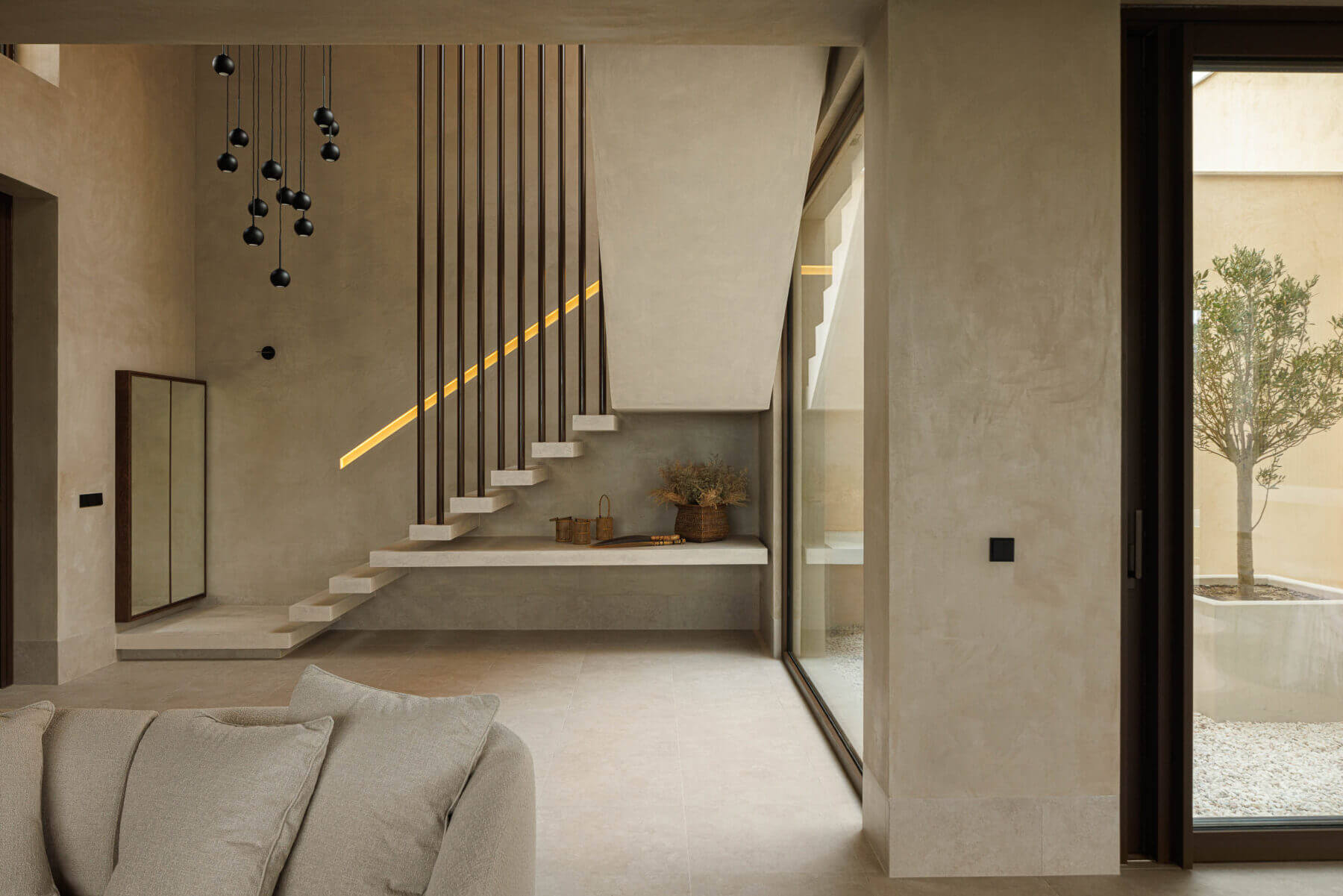 Escada: Escada com candeeiros suspensos e vista para o pátio interior com oliveira. — Parada das Estrelas arquitetura Solano Soto Architecture Studio em Óbidos