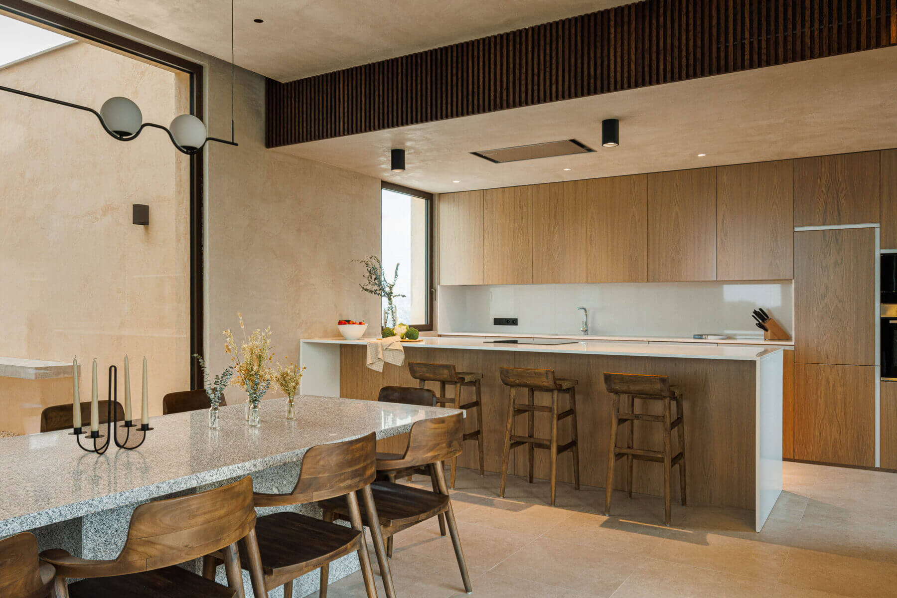 Cozinha: Armários em madeira clara, bancada em branco e mesa de jantar ao lado. — Parada das Estrelas arquitetura Solano Soto Architecture Studio em Óbidos