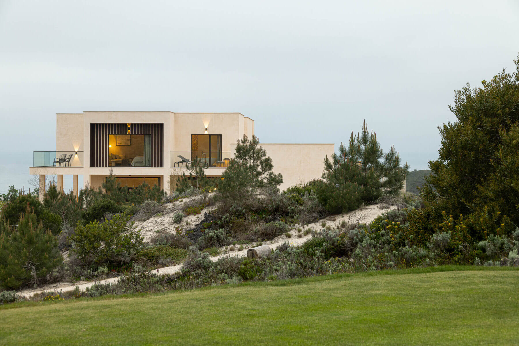 Exterior: Moradia integrada na paisagem com vegetação densa. — Parada das Estrelas arquitetura Solano Soto Architecture Studio em Óbidos