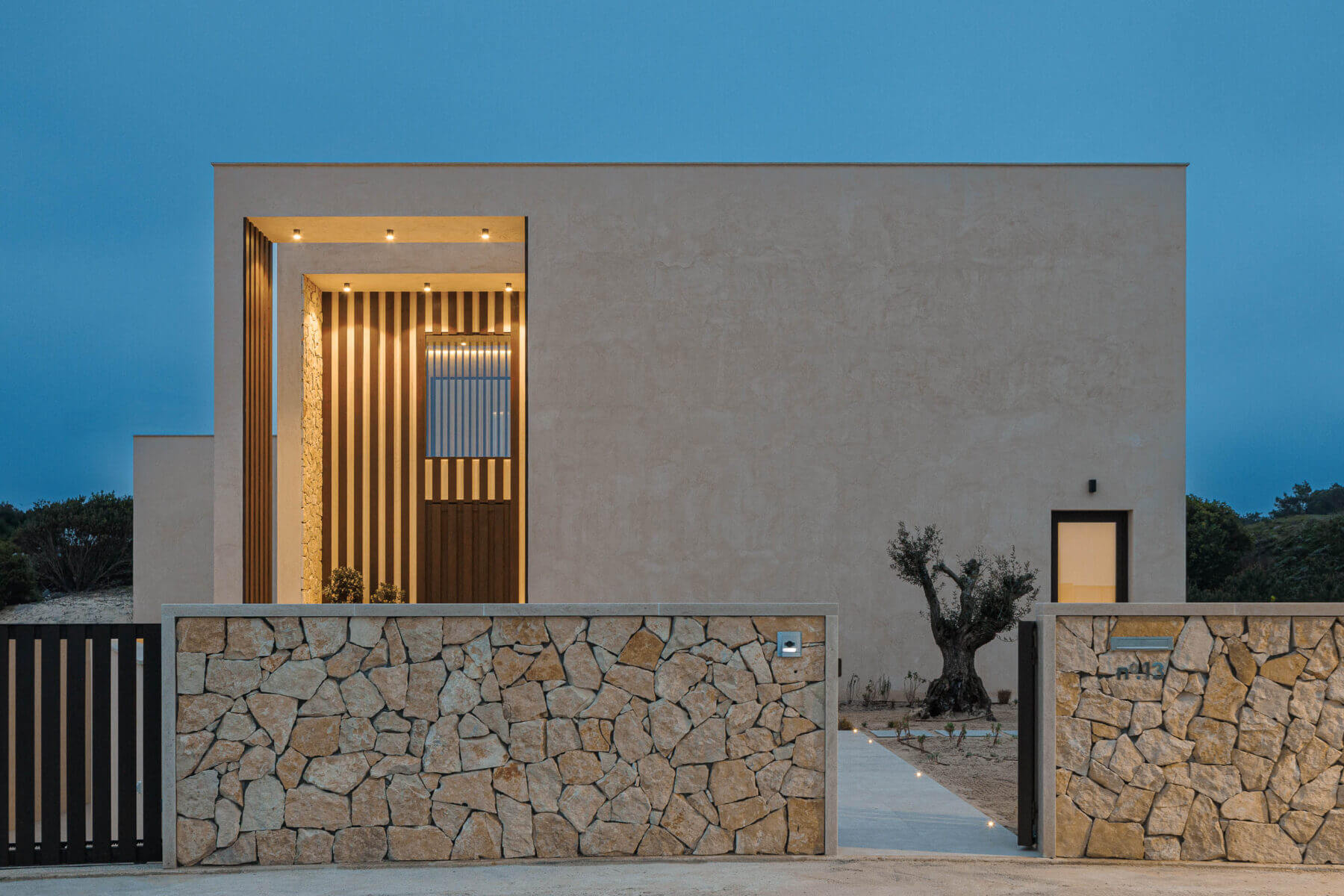 Exterior: Fachada principal com alpendre, oliveira e muro em pedra. — Parada das Estrelas arquitetura Solano Soto Architecture Studio em Óbidos