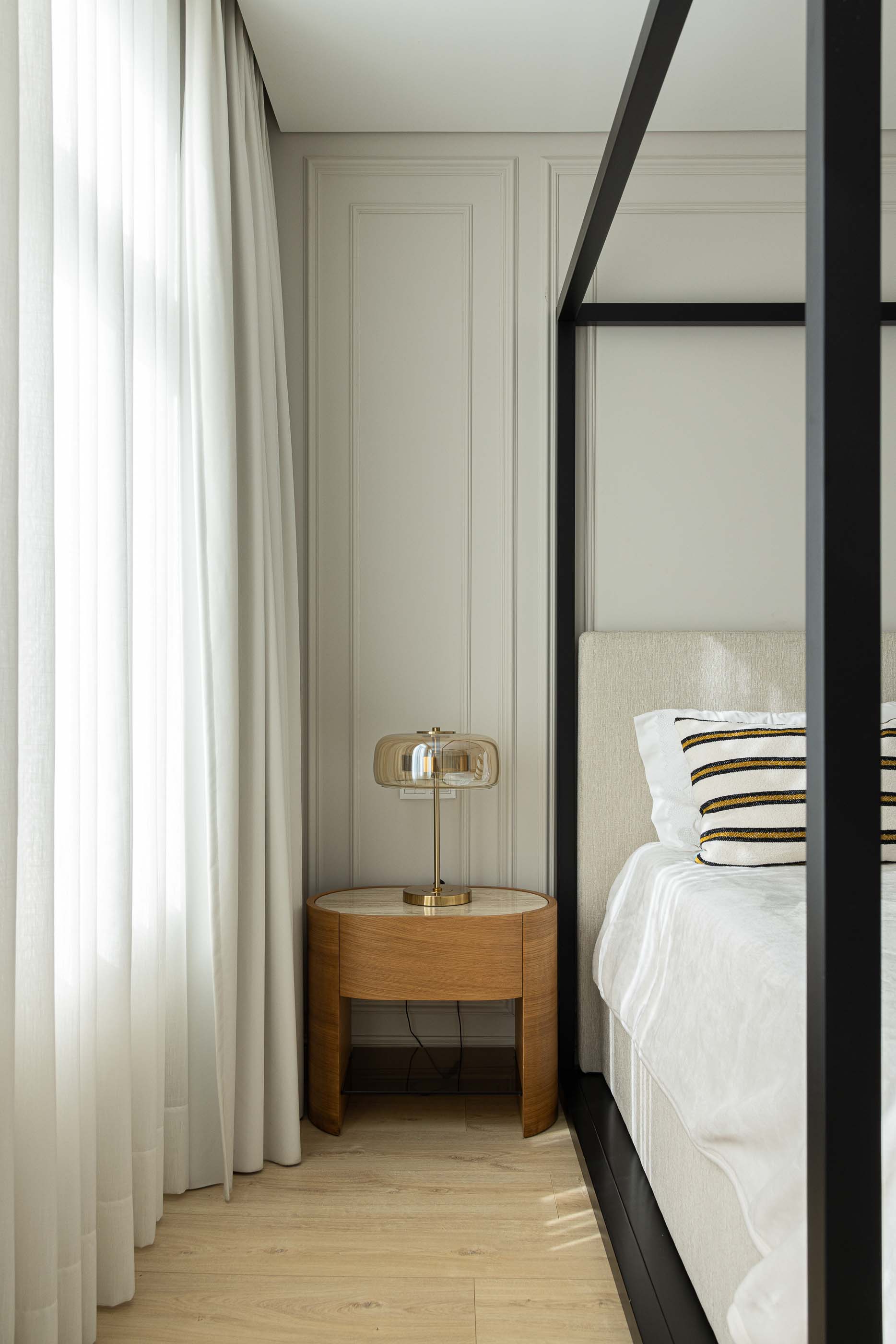 Quarto: Detalhe do quarto com cama de dossel preta, mesa de cabeceira em madeira e cortina branca. — Casa do Parque IV arquitetura Ricardo Azevedo Arquitecto em Santo Tirso
