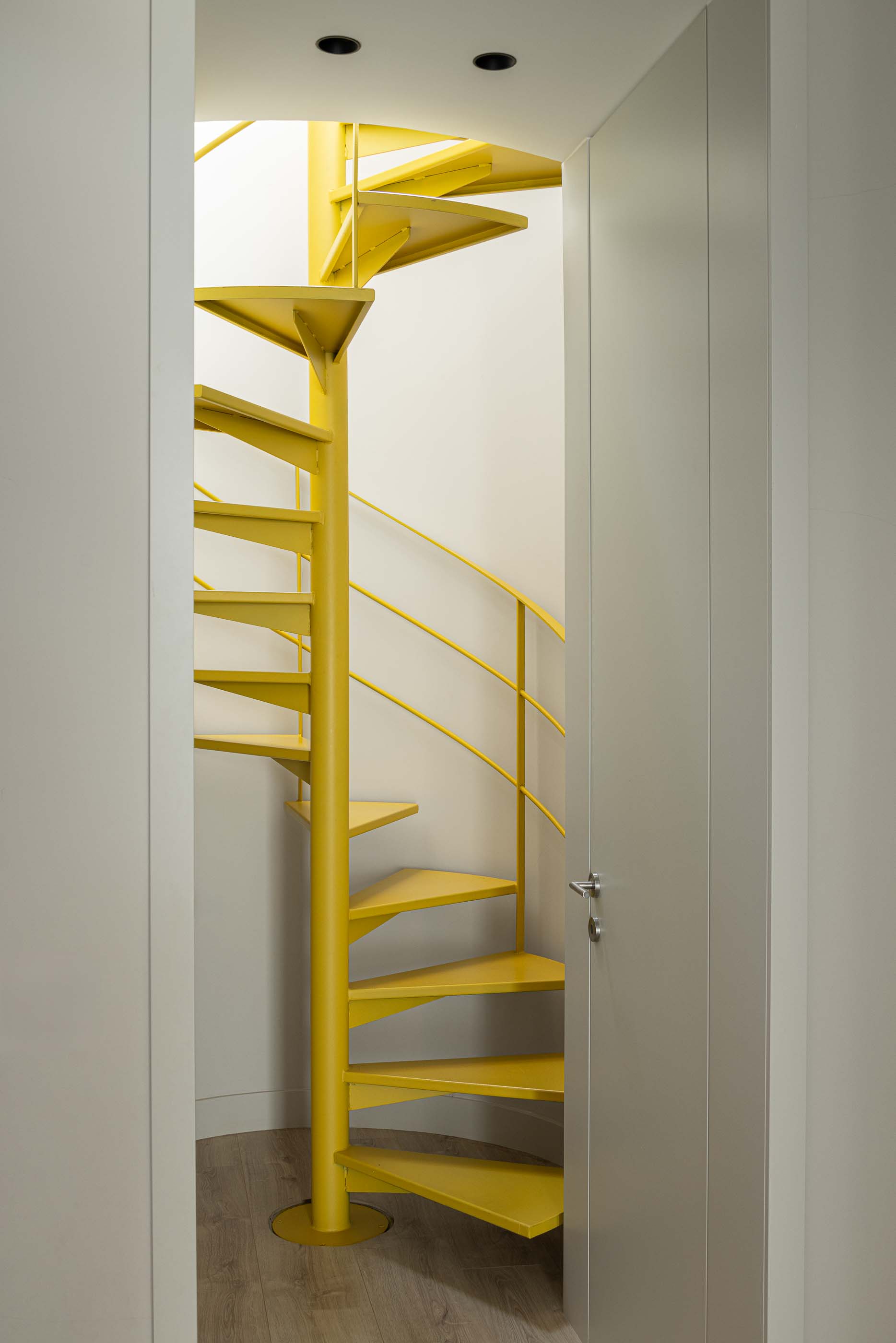 Escadas: Escada em caracol amarela que liga os pisos superiores da casa. — Casa do Parque IV arquitetura Ricardo Azevedo Arquitecto em Santo Tirso