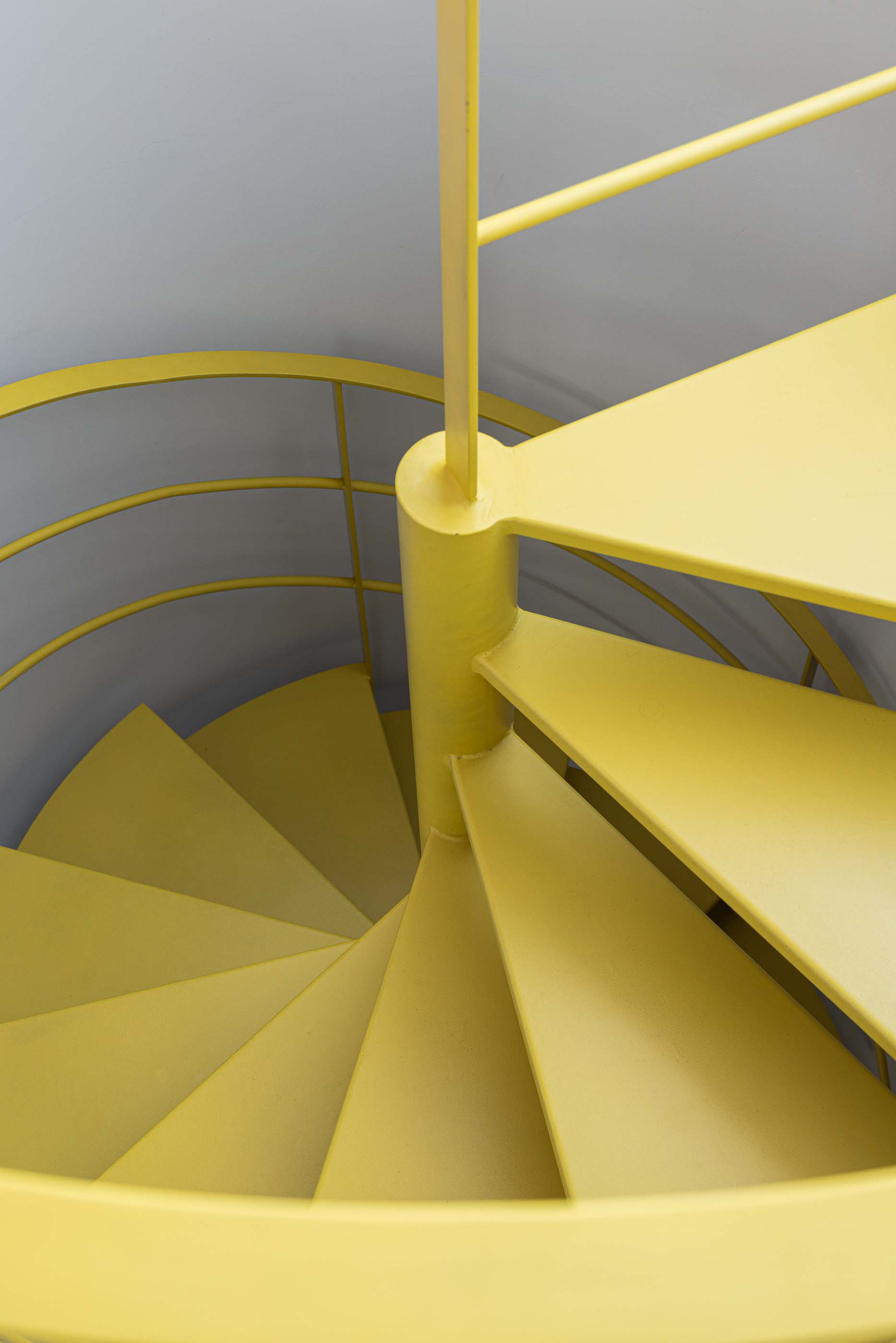 Escadas: Detalhe da escada em caracol amarela com degraus triangulares. — Casa do Parque IV arquitetura Ricardo Azevedo Arquitecto em Santo Tirso