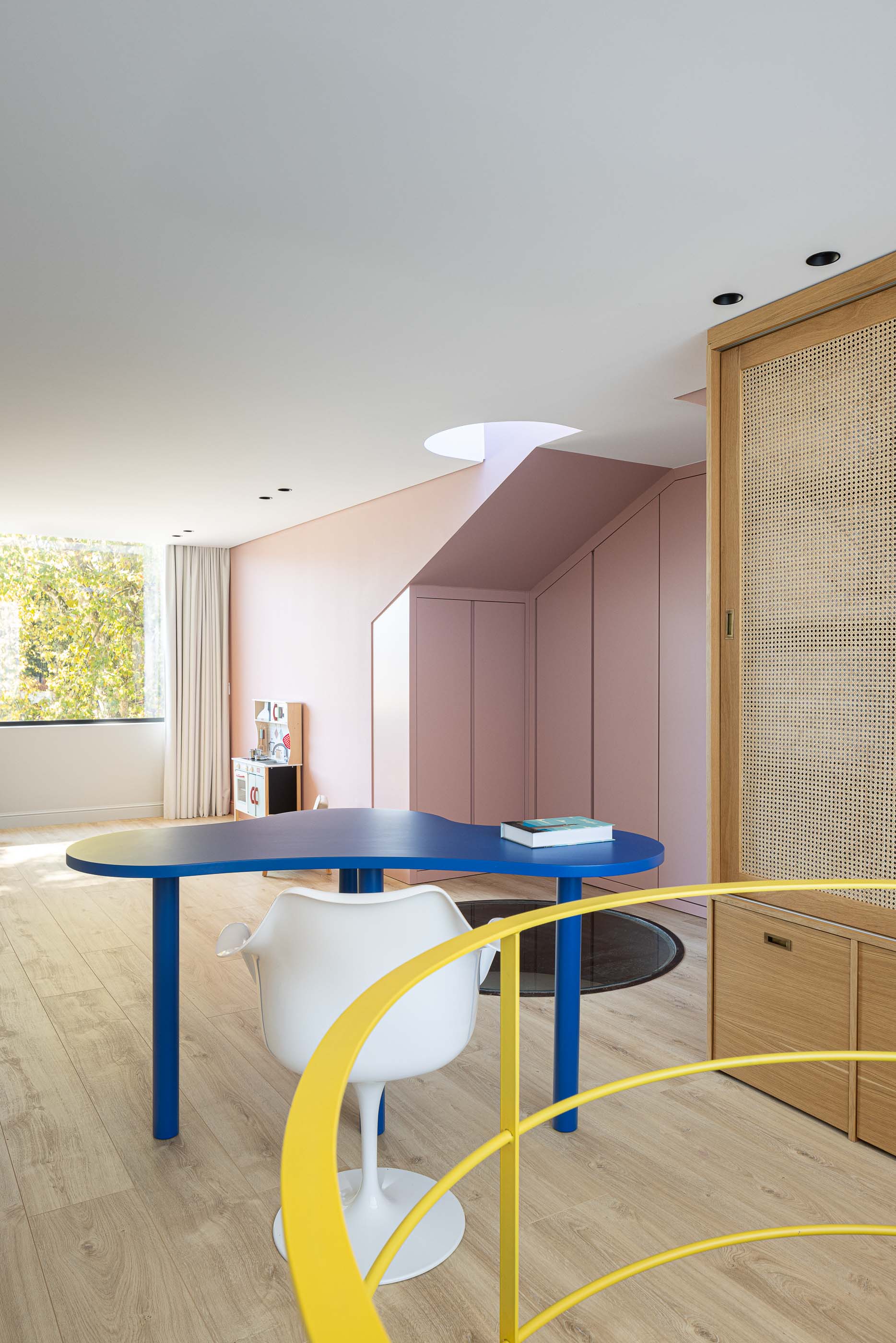 Quarto: Quarto infantil com secretária azul, cadeira branca e armário em madeira com palhinha. — Casa do Parque IV arquitetura Ricardo Azevedo Arquitecto em Santo Tirso