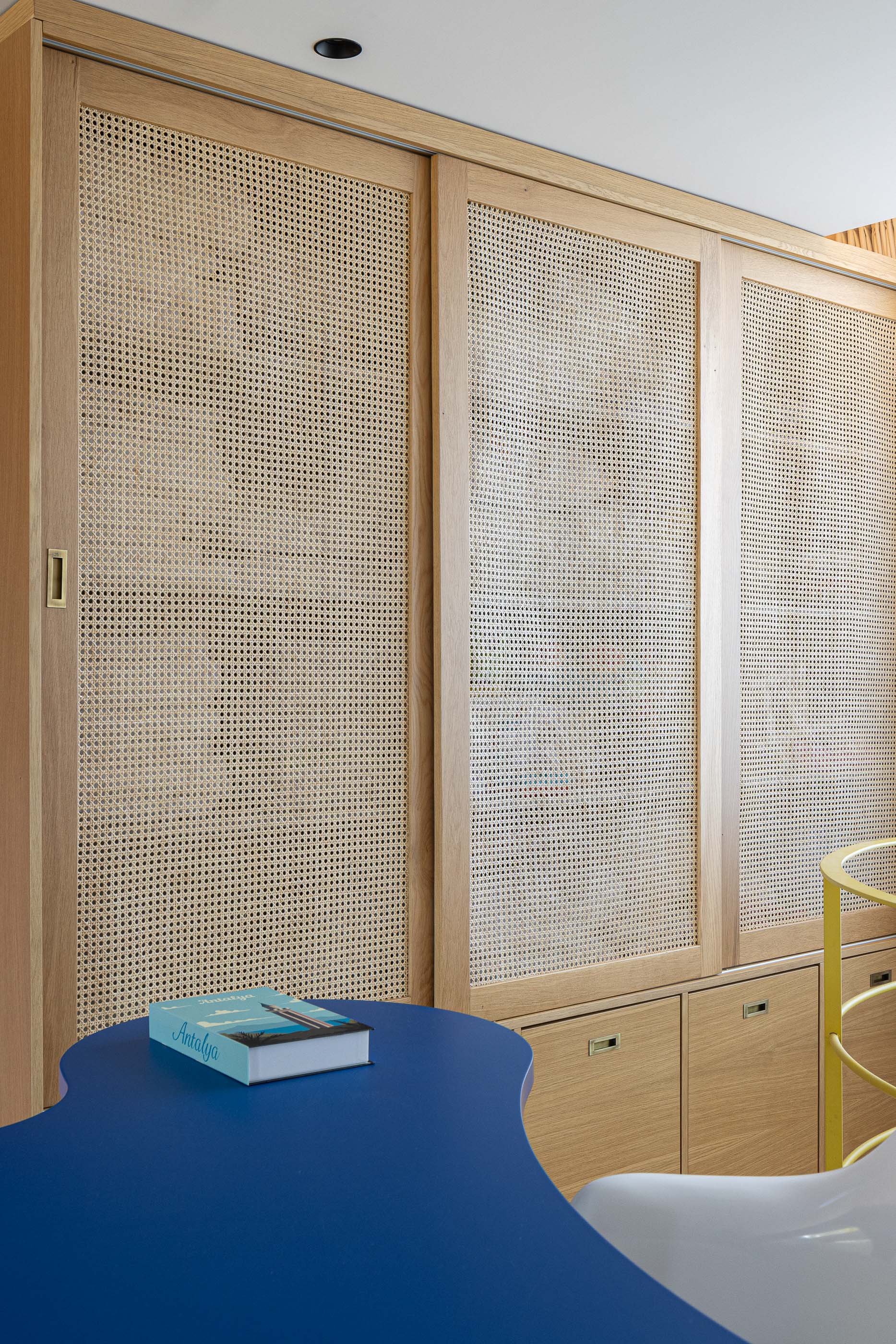 Quarto: Detalhe do armário em madeira com palhinha e secretária azul no quarto infantil. — Casa do Parque IV arquitetura Ricardo Azevedo Arquitecto em Santo Tirso