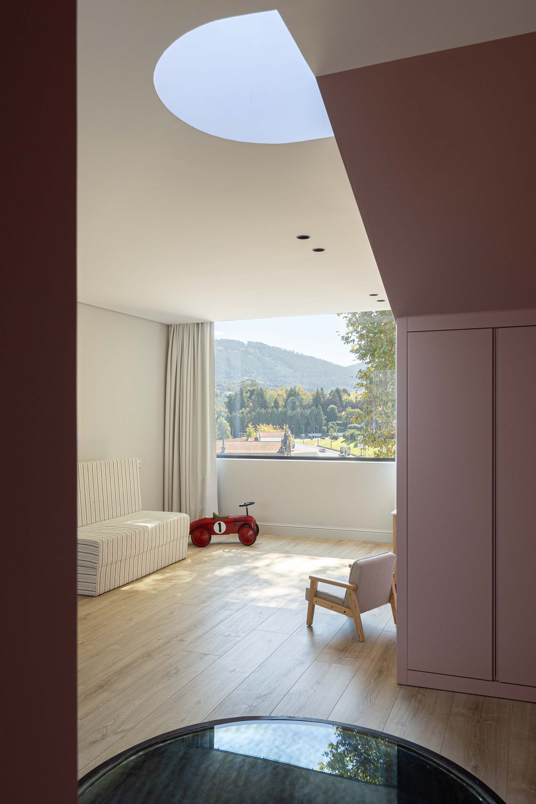 Quarto: Quarto infantil com cama, sofá e vista para a paisagem através da janela. — Casa do Parque IV arquitetura Ricardo Azevedo Arquitecto em Santo Tirso
