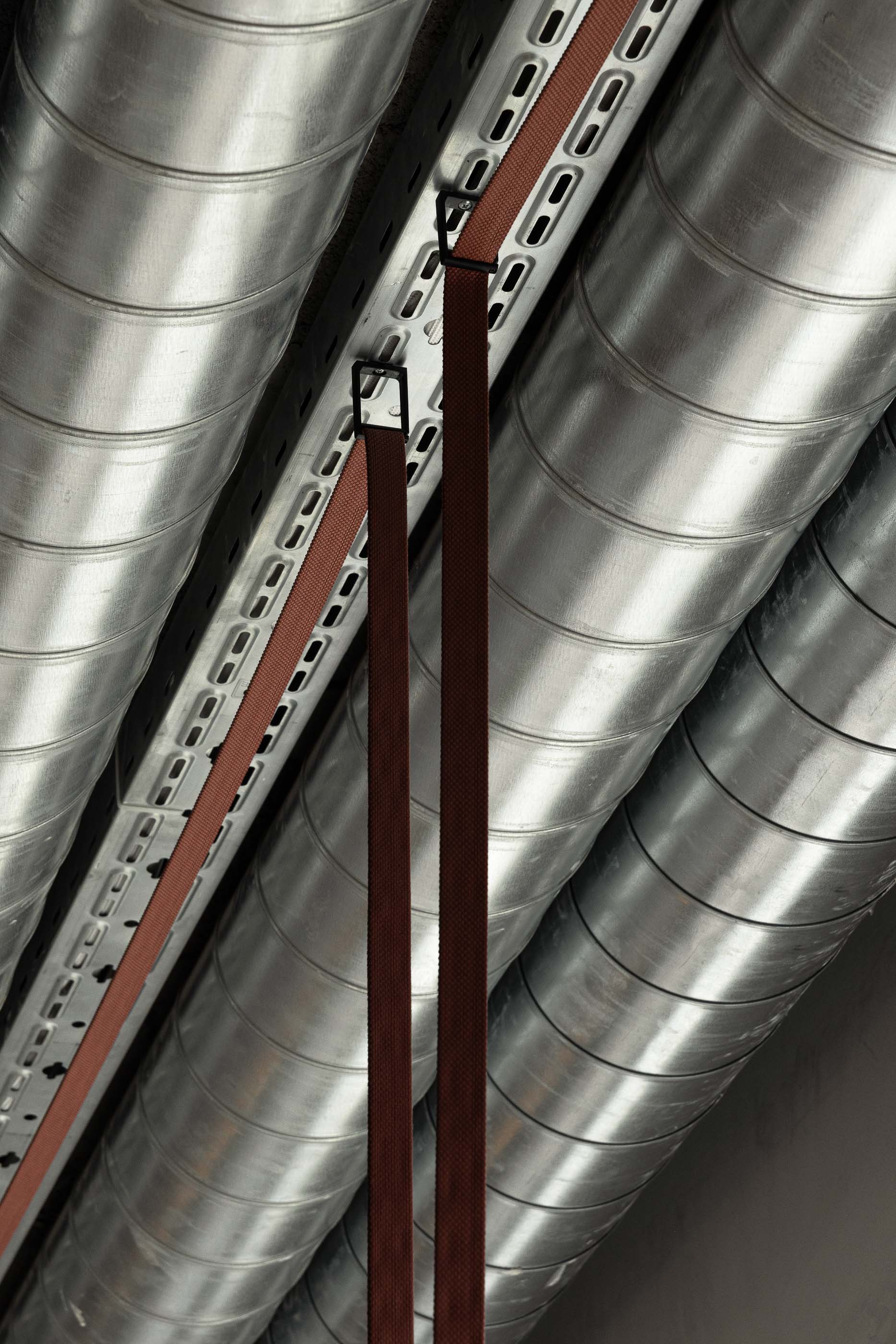 Tecto: Detalhe de tubagens expostas no tecto com fitas cor de tijolo. — KI.art.music.coffee arquitetura MAT Arquitetura e Interiores em Porto