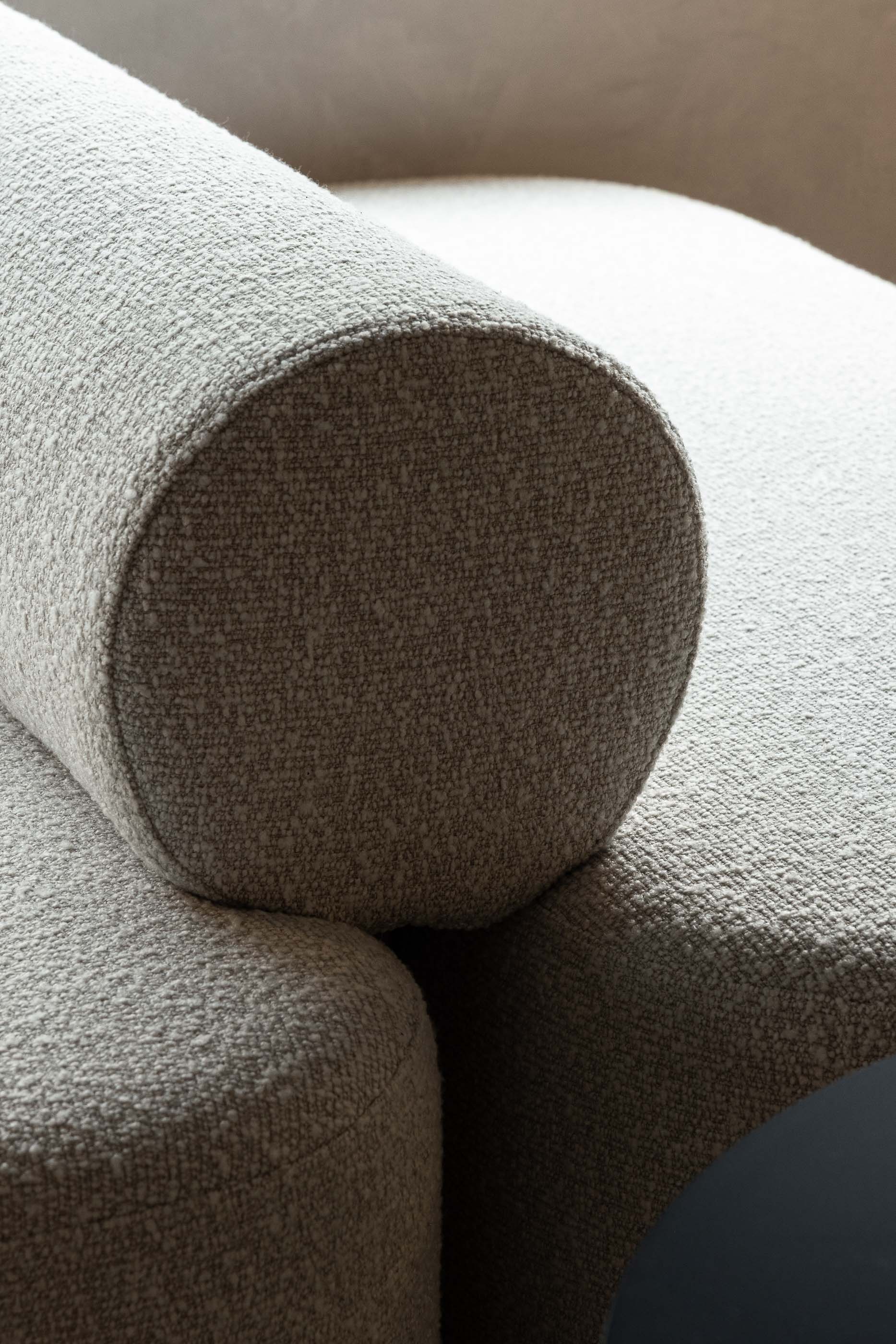 Detalhe do sofá: Textura do tecido branco do sofá com encosto cilíndrico e mesa preta. — KI.art.music.coffee arquitetura MAT Arquitetura e Interiores em Porto