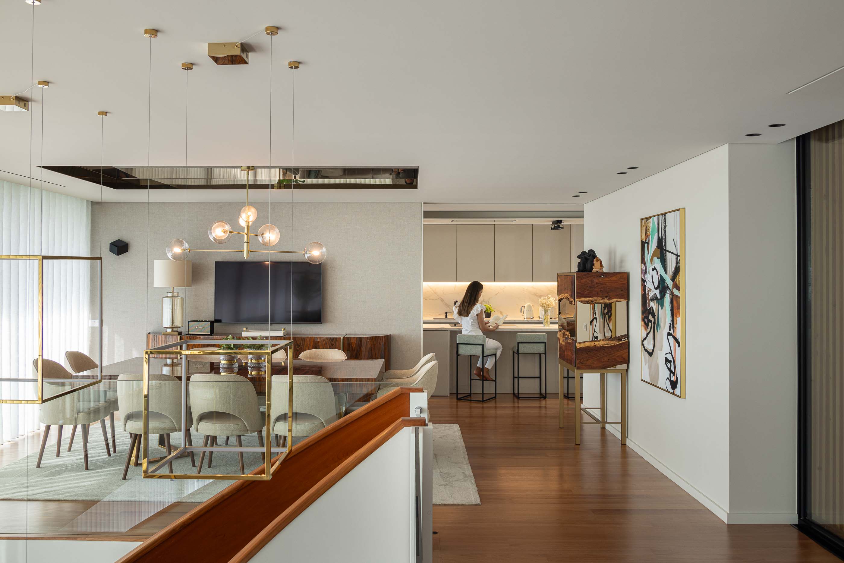Sala de estar/Jantar: Sala de estar e jantar com mesa de jantar, cadeiras, candeeiros suspensos e vista para a cozinha. — Casa da Encosta arquitetura Ricardo Azevedo Arquitecto em Santo Tirso