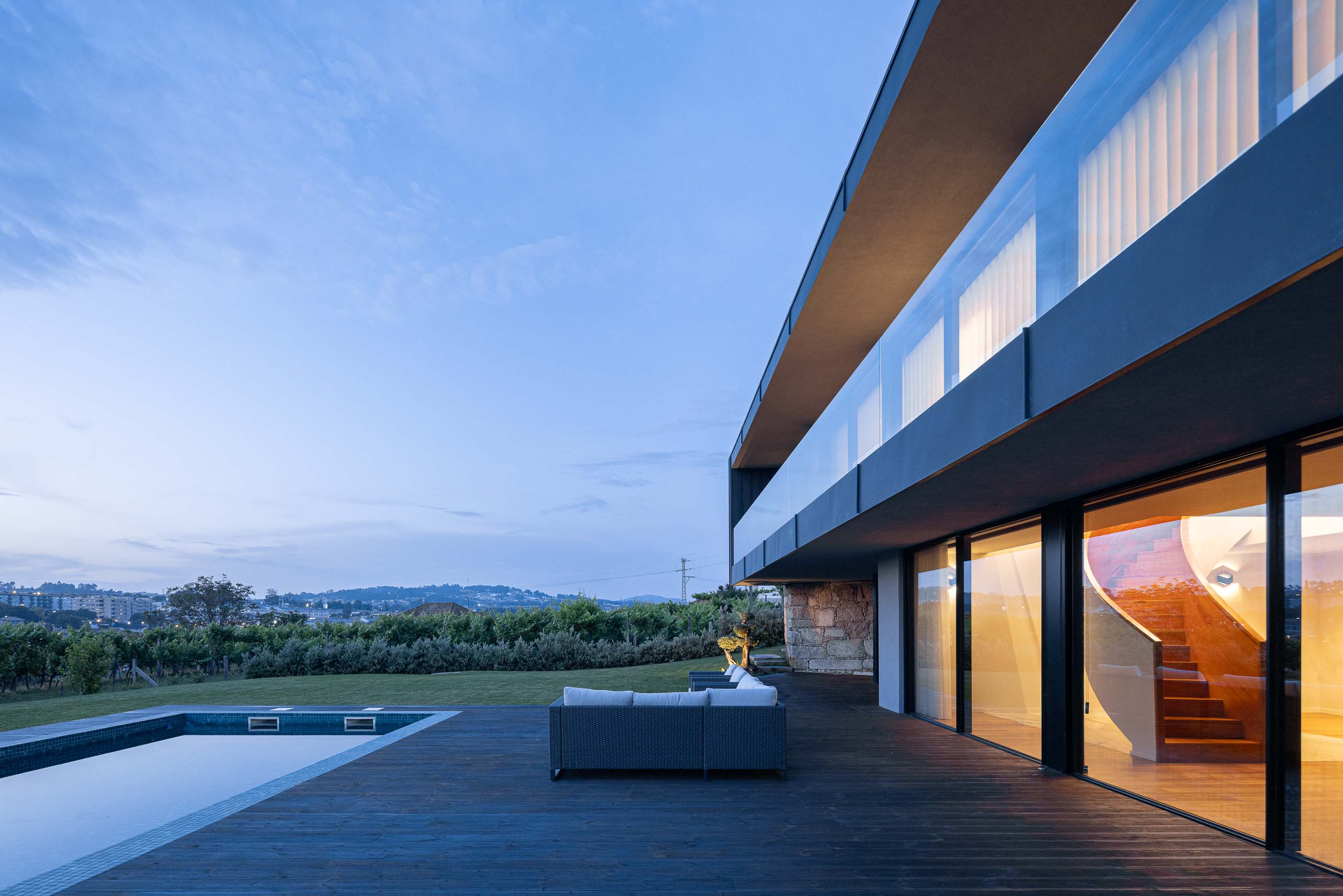 Exterior: Vista da piscina, zona de estar exterior e escadas de acesso ao piso superior. Arquitetura moderna e minimalista. — Casa da Encosta arquitetura Ricardo Azevedo Arquitecto em Santo Tirso