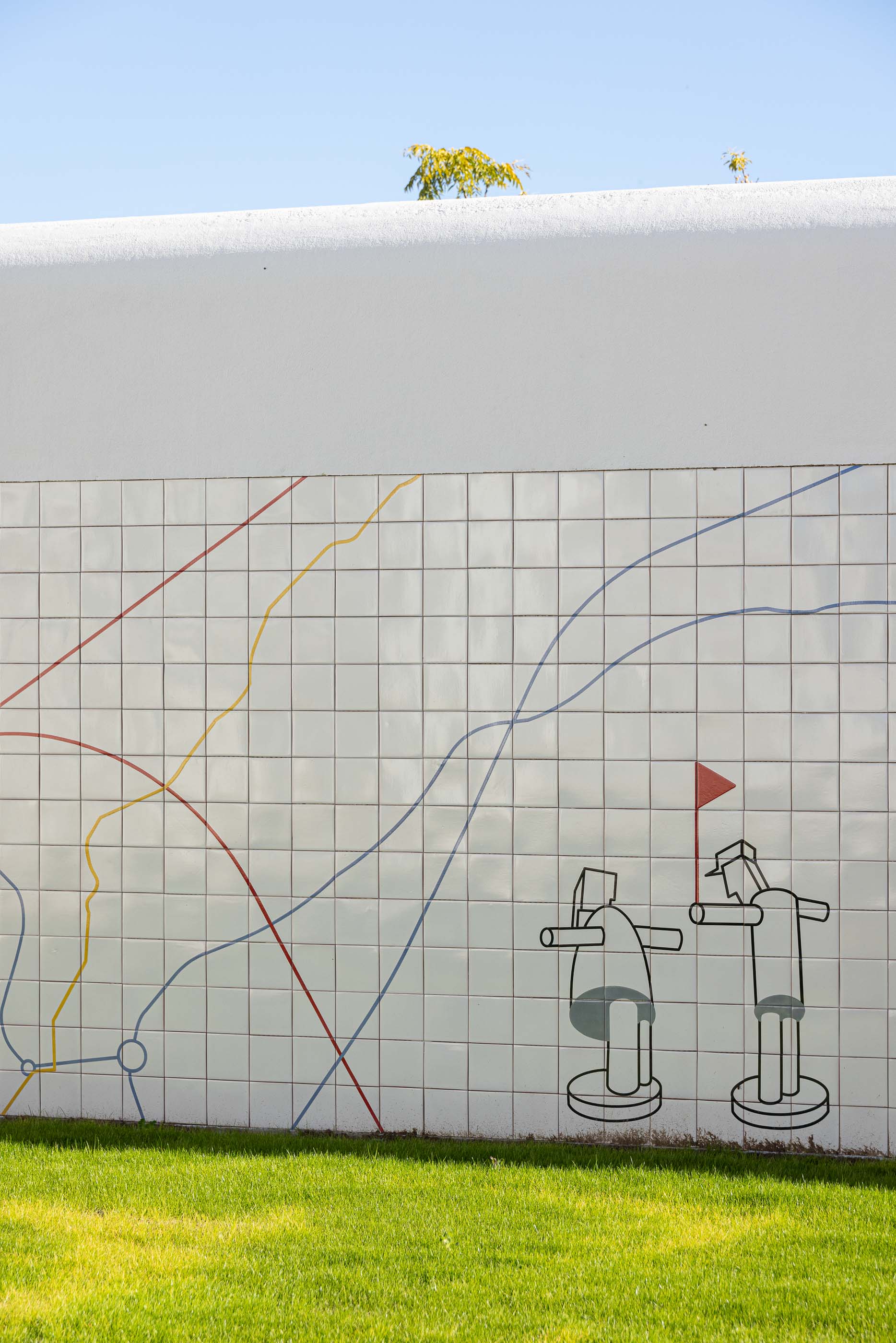 Exterior: Muro revestido com azulejos brancos e desenho linear a cores, representando um mapa. — Reabilitação Urbana do Bairro do Boneco arquitetura Adarq - André David Arquitecto em Entroncamento