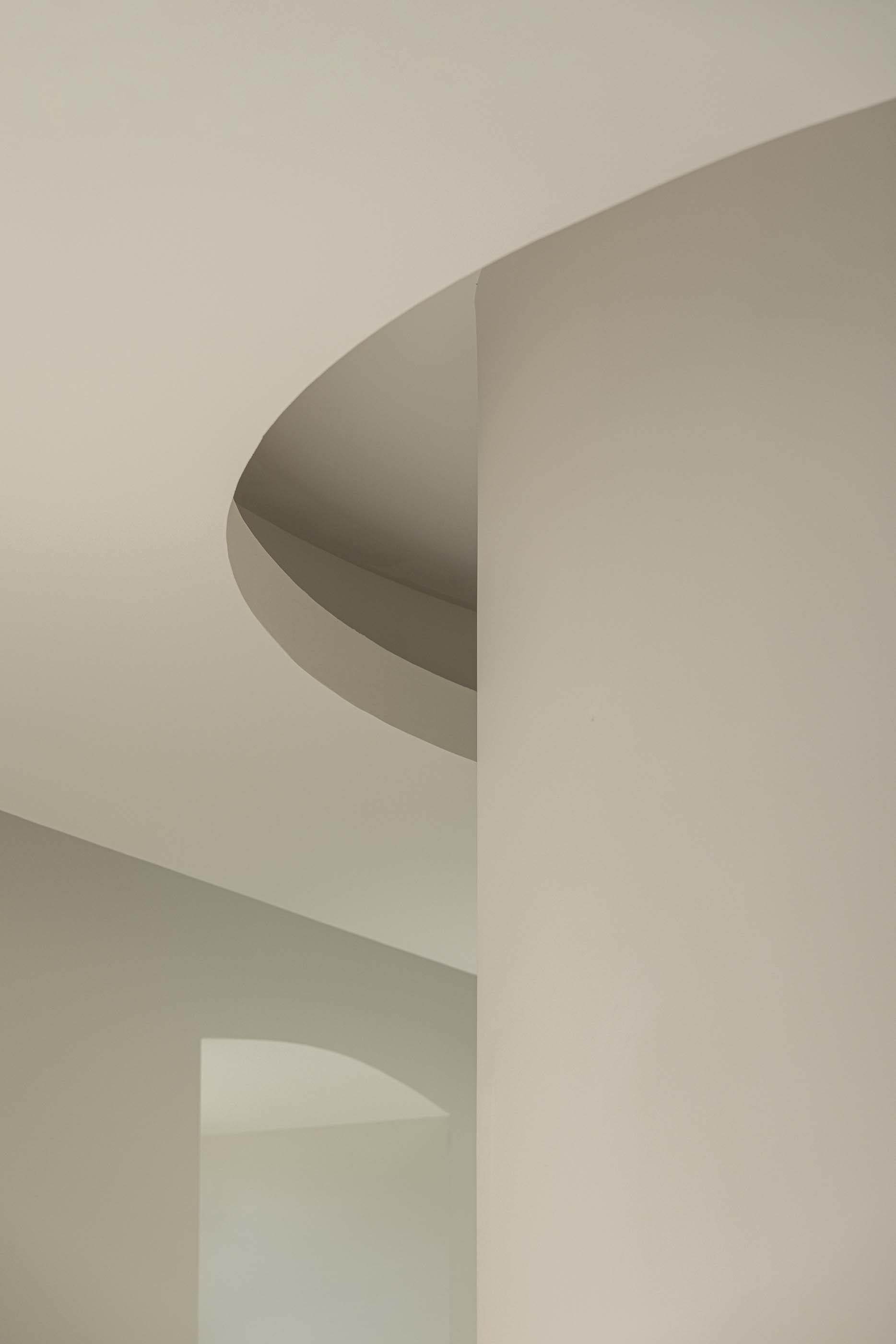 Detalhe arquitetónico: Interseção de planos curvos brancos, com iluminação natural. — Reabilitação Urbana do Bairro do Boneco arquitetura Adarq - André David Arquitecto em Entroncamento