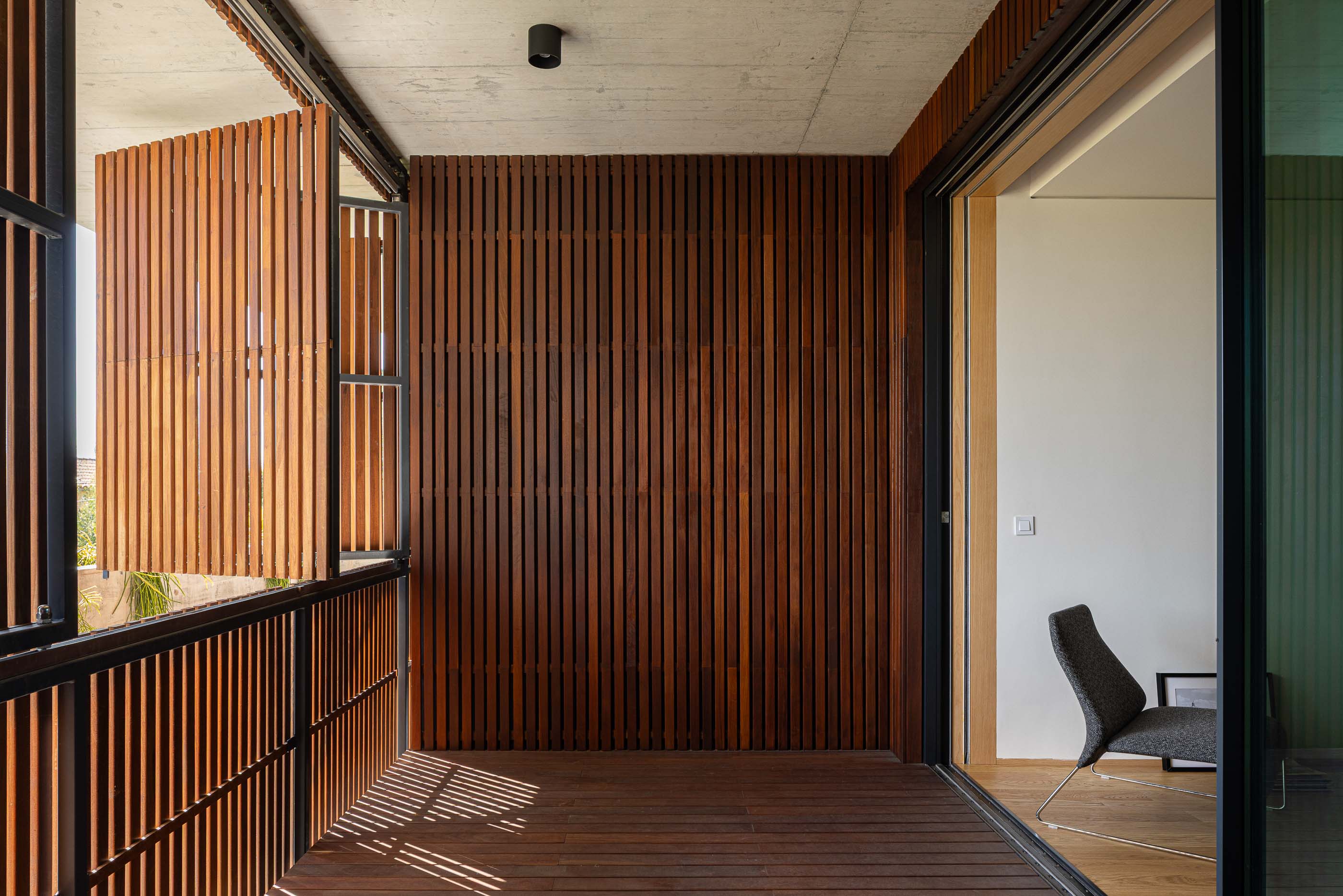 Varanda: Portadas de madeira e pavimento em madeira. — Casa M arquitetura silverline em Vila Nova de Gaia