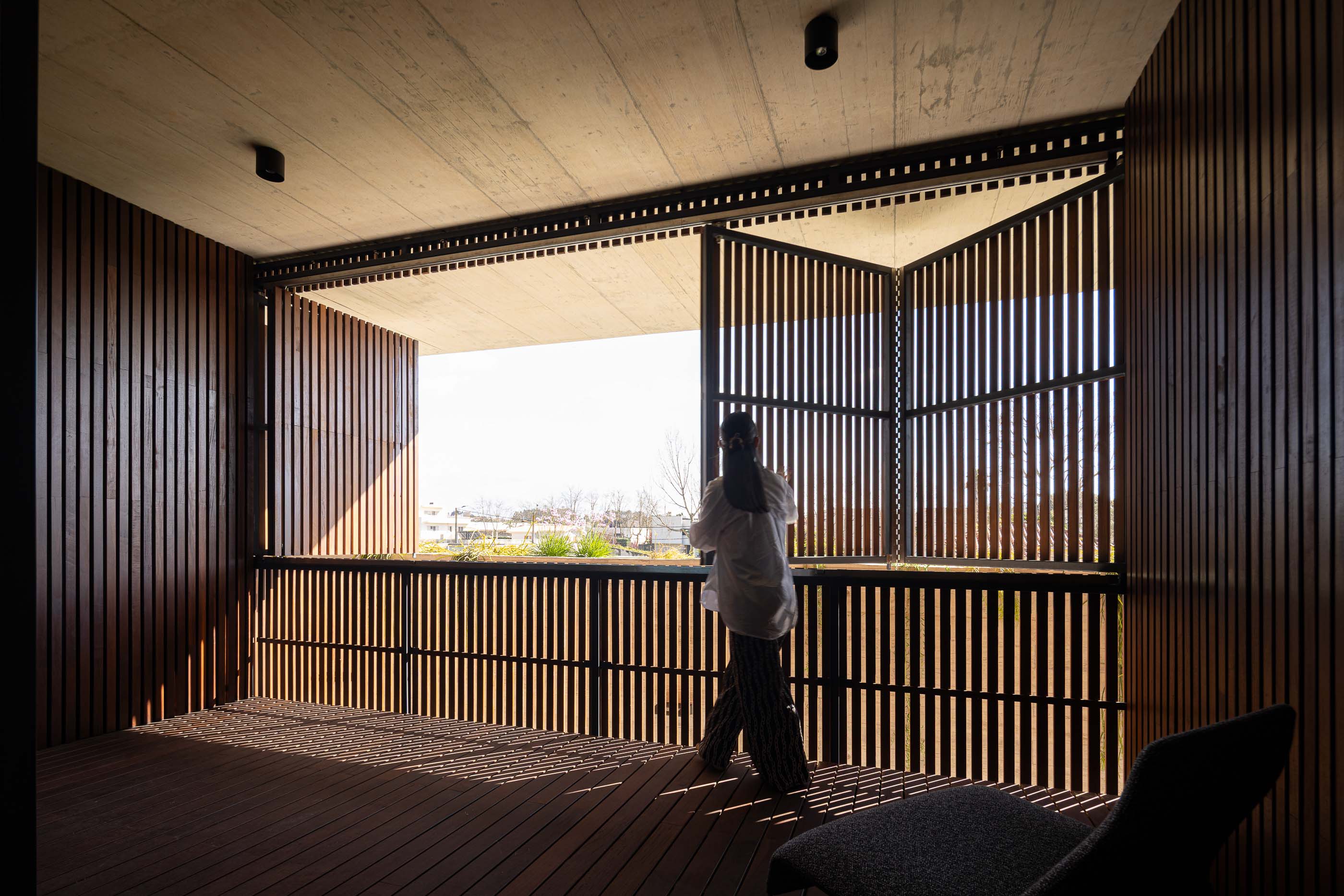 Varanda: Portadas de madeira e pavimento em madeira. — Casa M arquitetura silverline em Vila Nova de Gaia