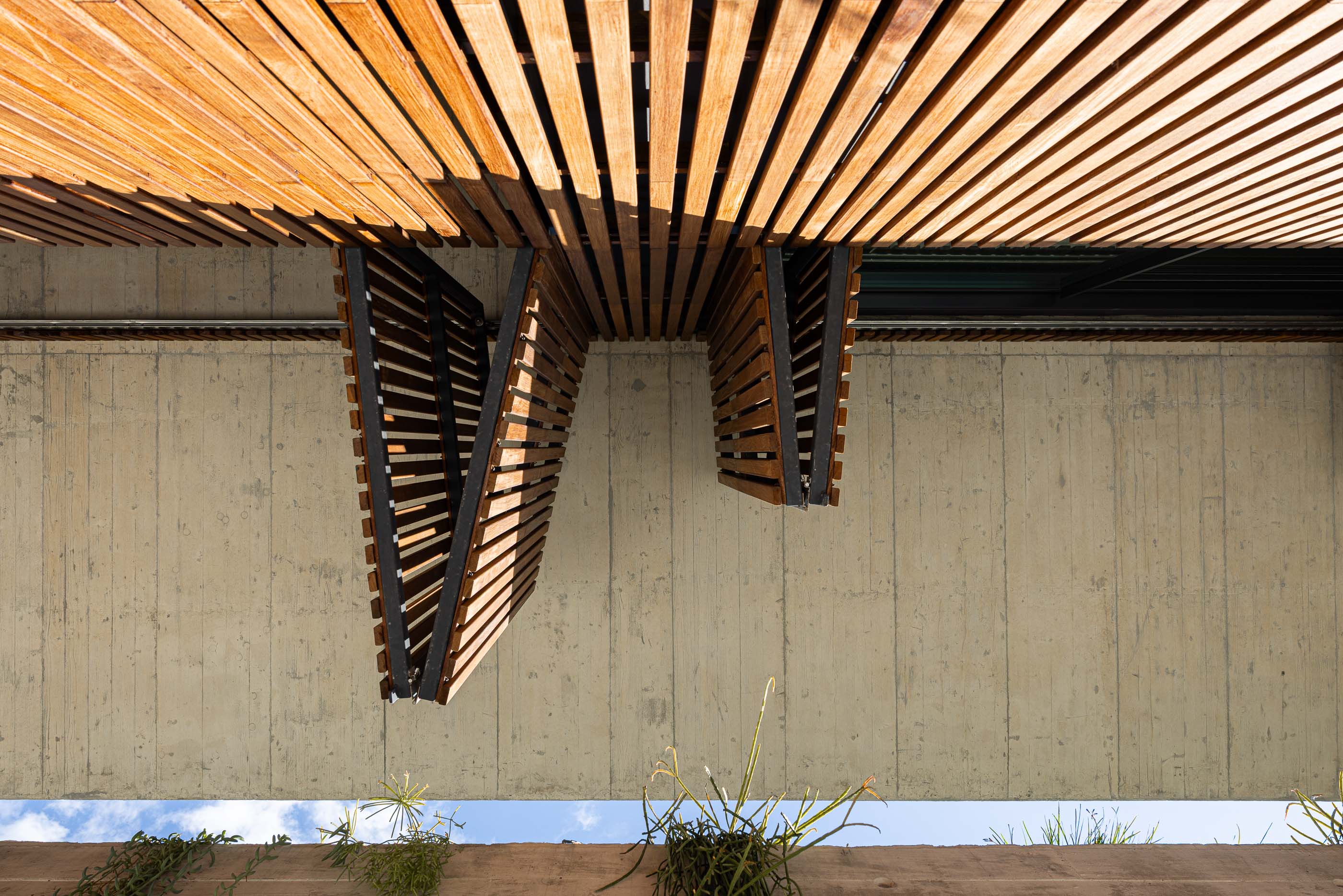 Exterior: Detalhe das portadas de madeira e betão aparente. — Casa M arquitetura silverline em Vila Nova de Gaia