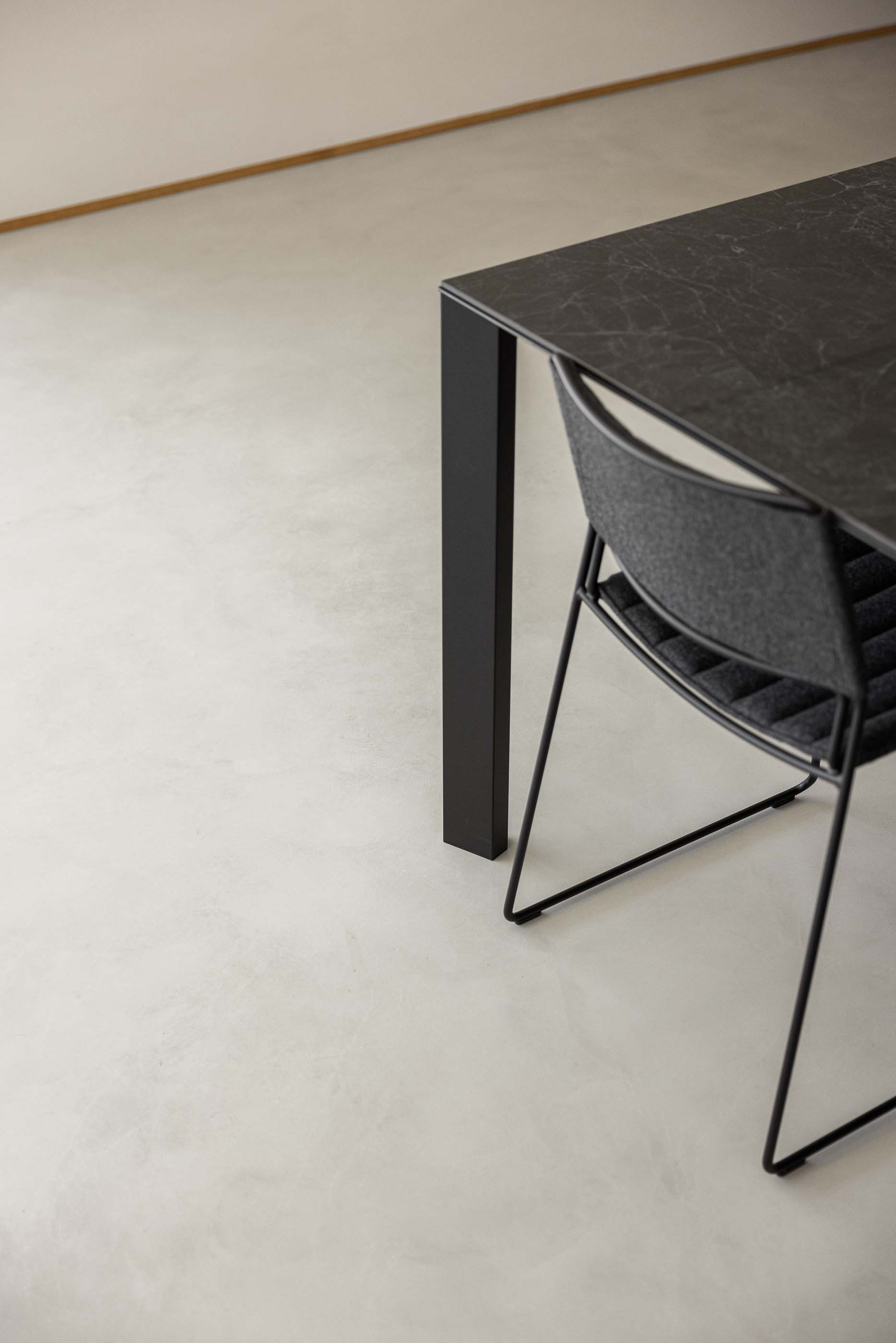 Sala de jantar: Detalhe da mesa de jantar preta e cadeira cinzenta. — Casa M arquitetura silverline em Vila Nova de Gaia