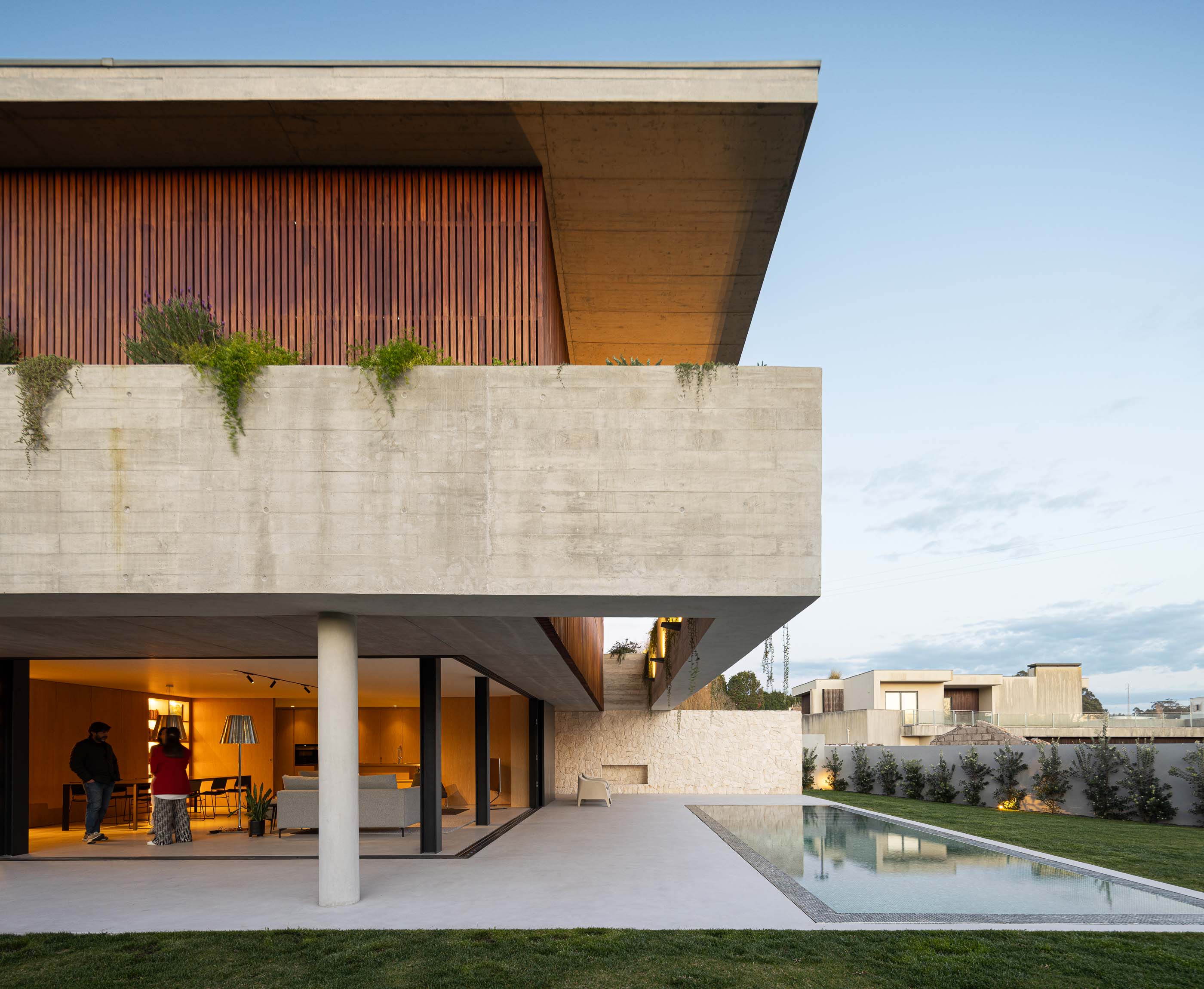 Exterior: Vista da casa com piscina, relvado e iluminação exterior. — Casa M arquitetura silverline em Vila Nova de Gaia