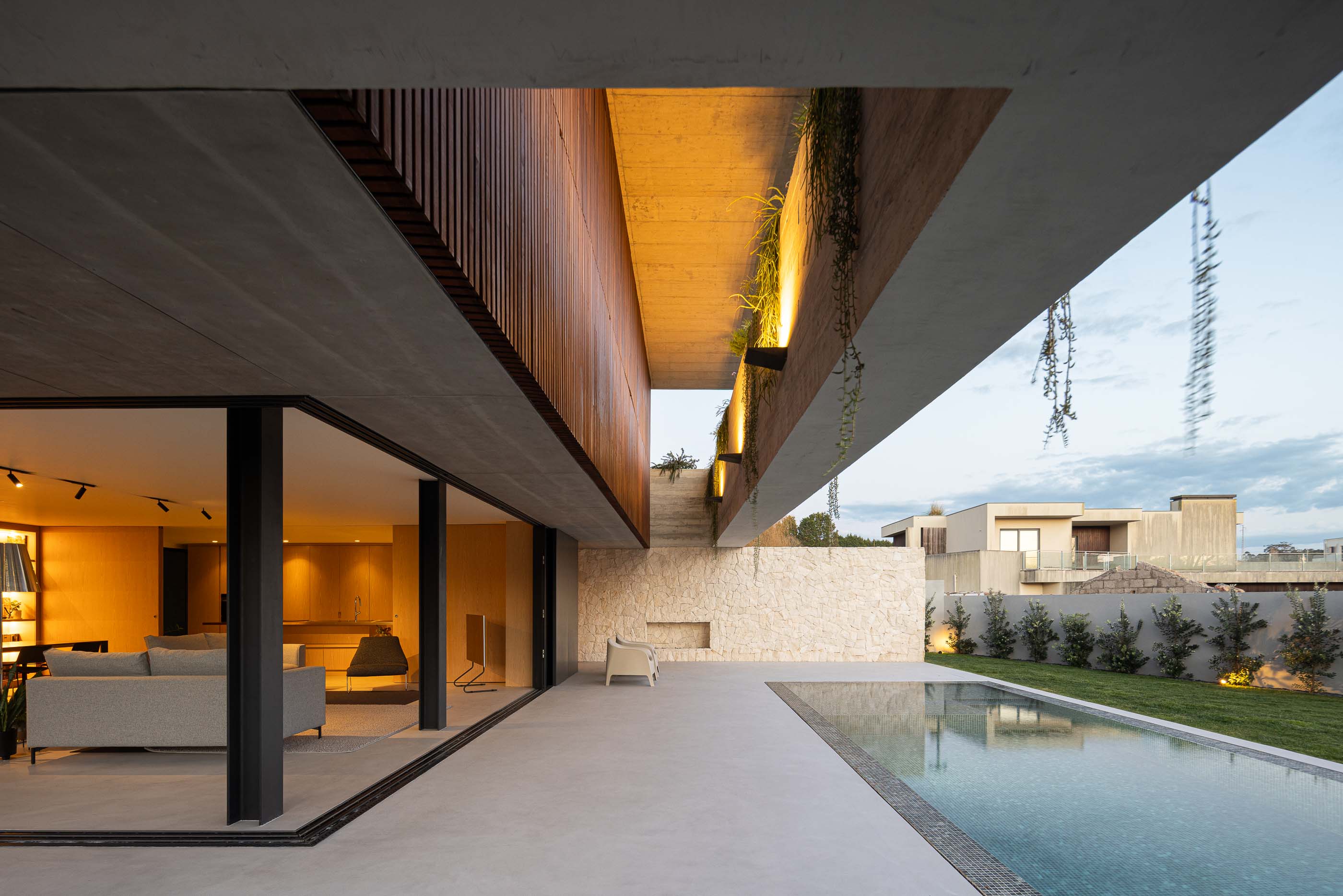 Exterior: Vista da casa com piscina, relvado e iluminação exterior. — Casa M arquitetura silverline em Vila Nova de Gaia