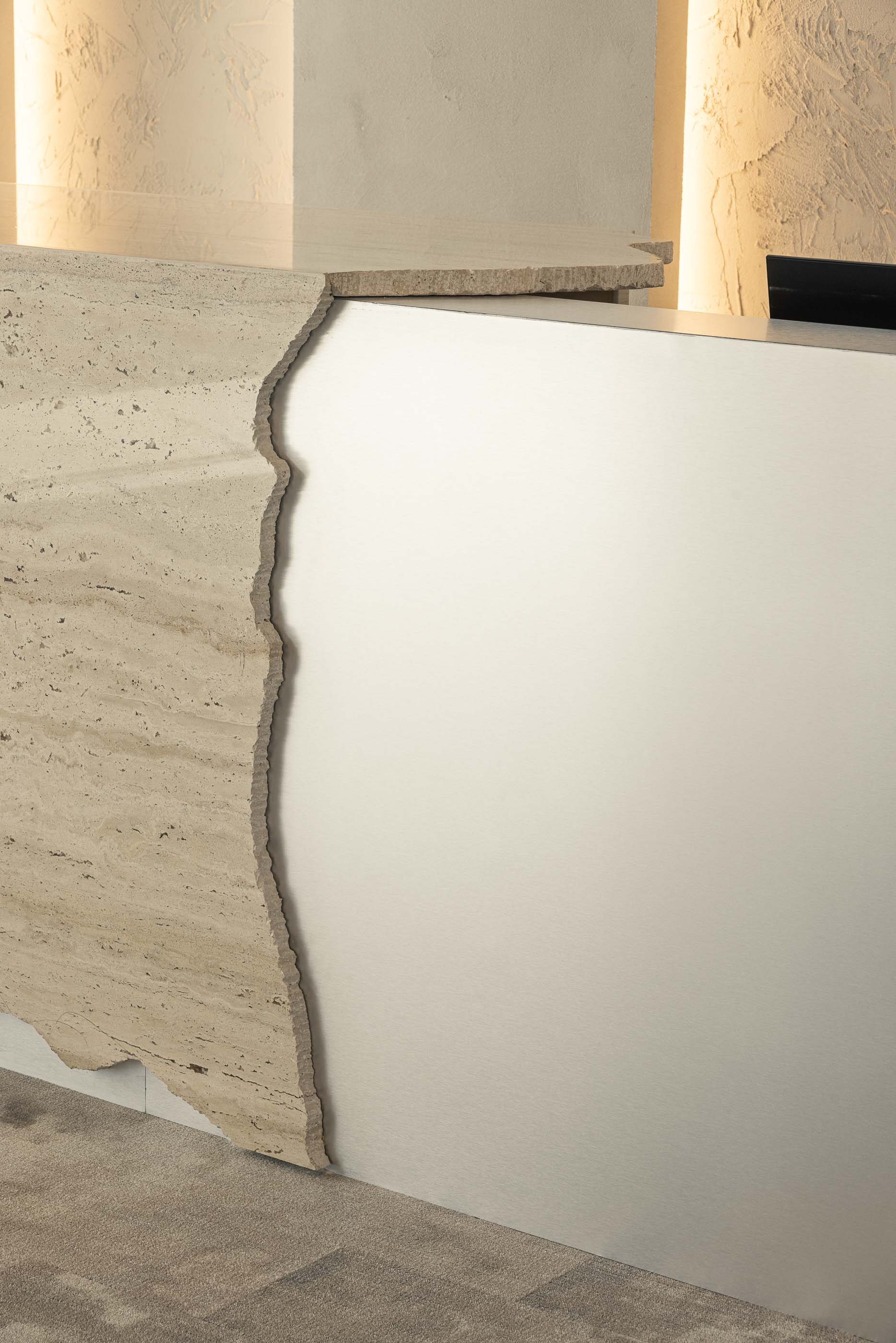 Recepção: Detalhe do balcão em travertino e espelho, com alcatifa cinzenta. — Oporto MAZARS offices arquitetura GRAU.ZERO Arquitectura em Porto