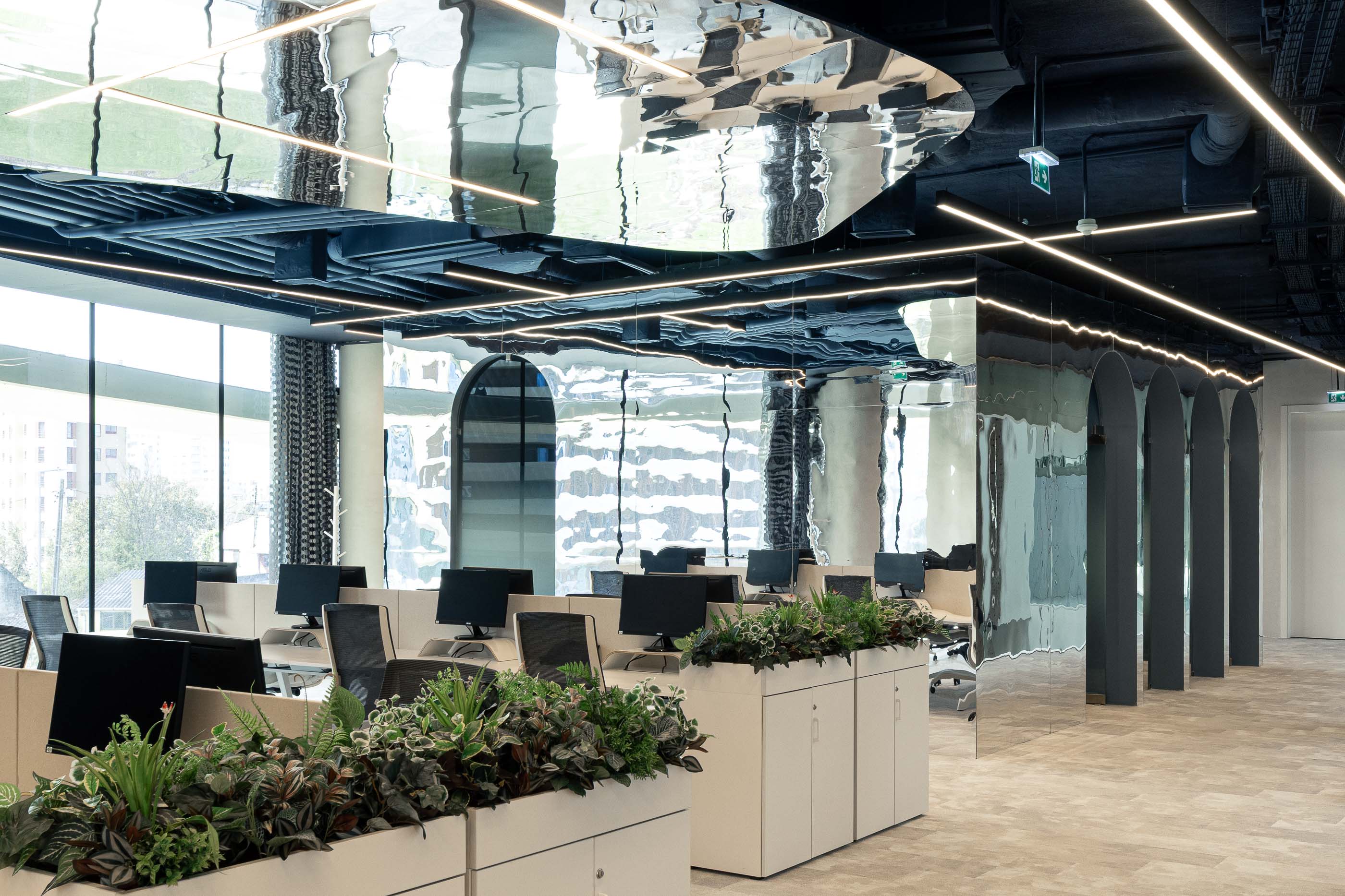 Escritório: Open space com secretárias brancas, plantas e divisórias em arco espelhadas. — Oporto MAZARS offices arquitetura GRAU.ZERO Arquitectura em Porto