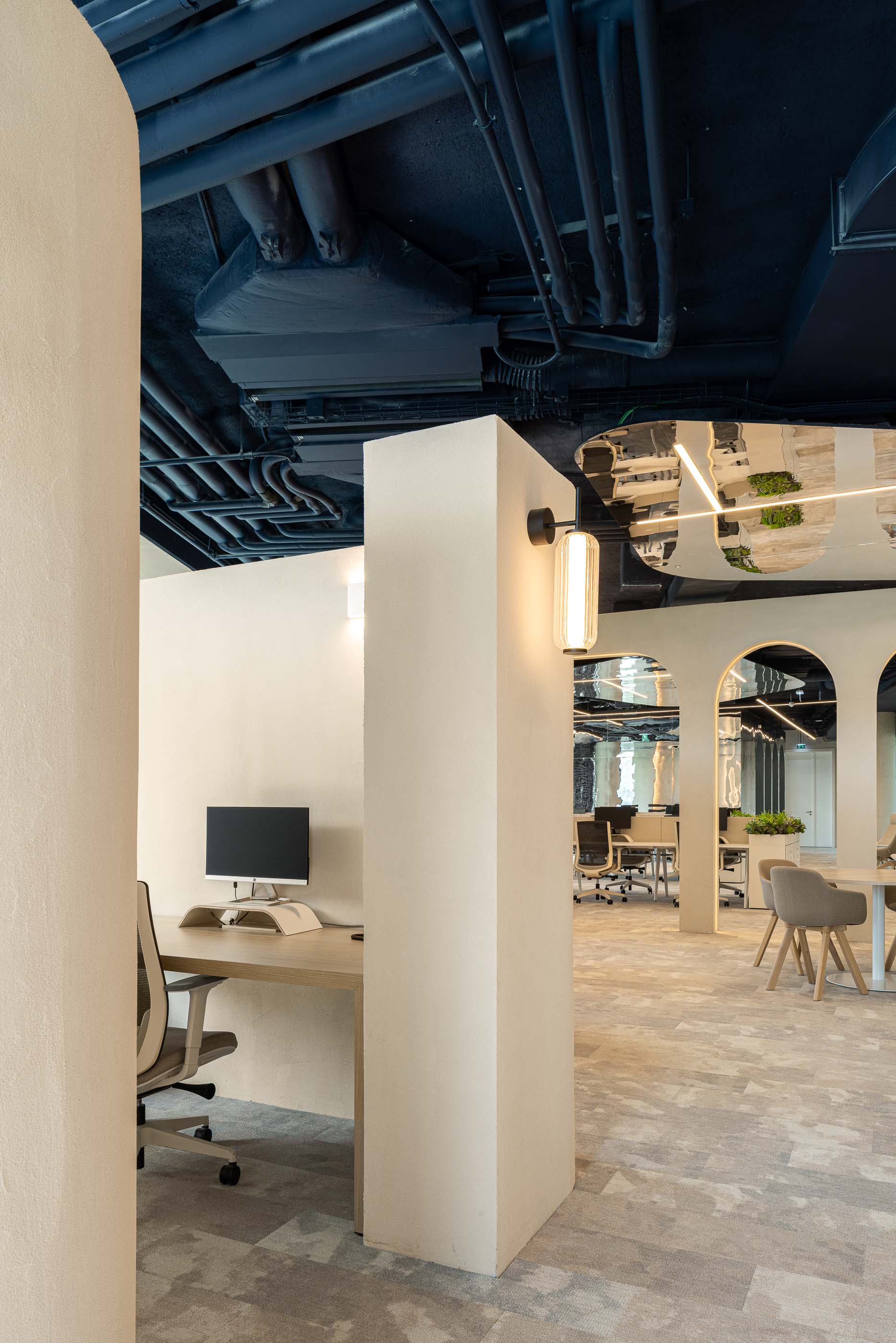 Escritório: Secretária individual junto a coluna texturada, com candeeiro de parede e alcatifa cinzenta. — Oporto MAZARS offices arquitetura GRAU.ZERO Arquitectura em Porto