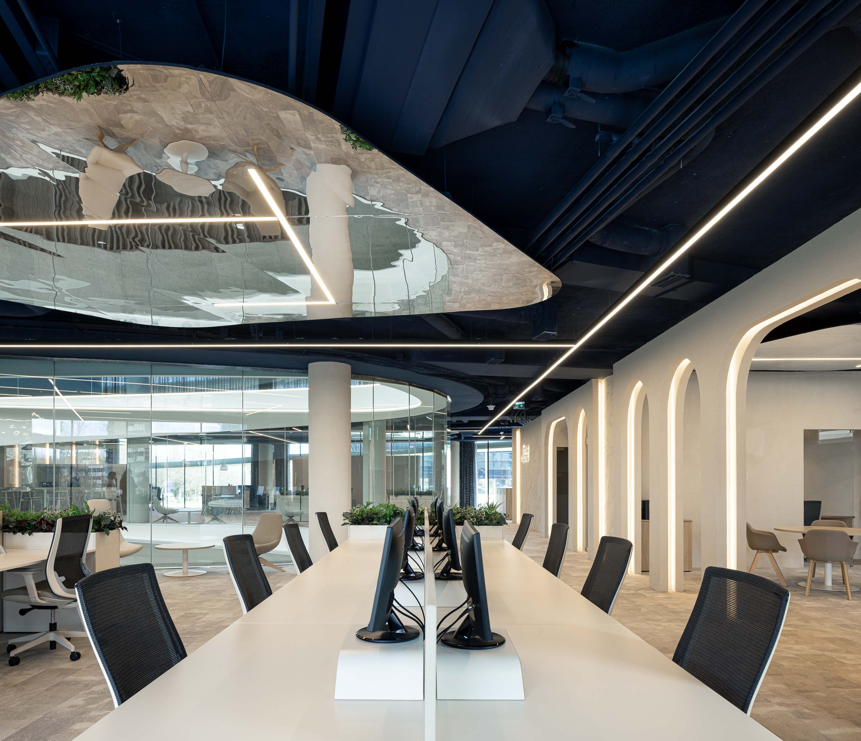 Escritório: Open space com secretárias brancas, plantas e teto espelhado com iluminação linear. — Oporto MAZARS offices arquitetura GRAU.ZERO Arquitectura em Porto