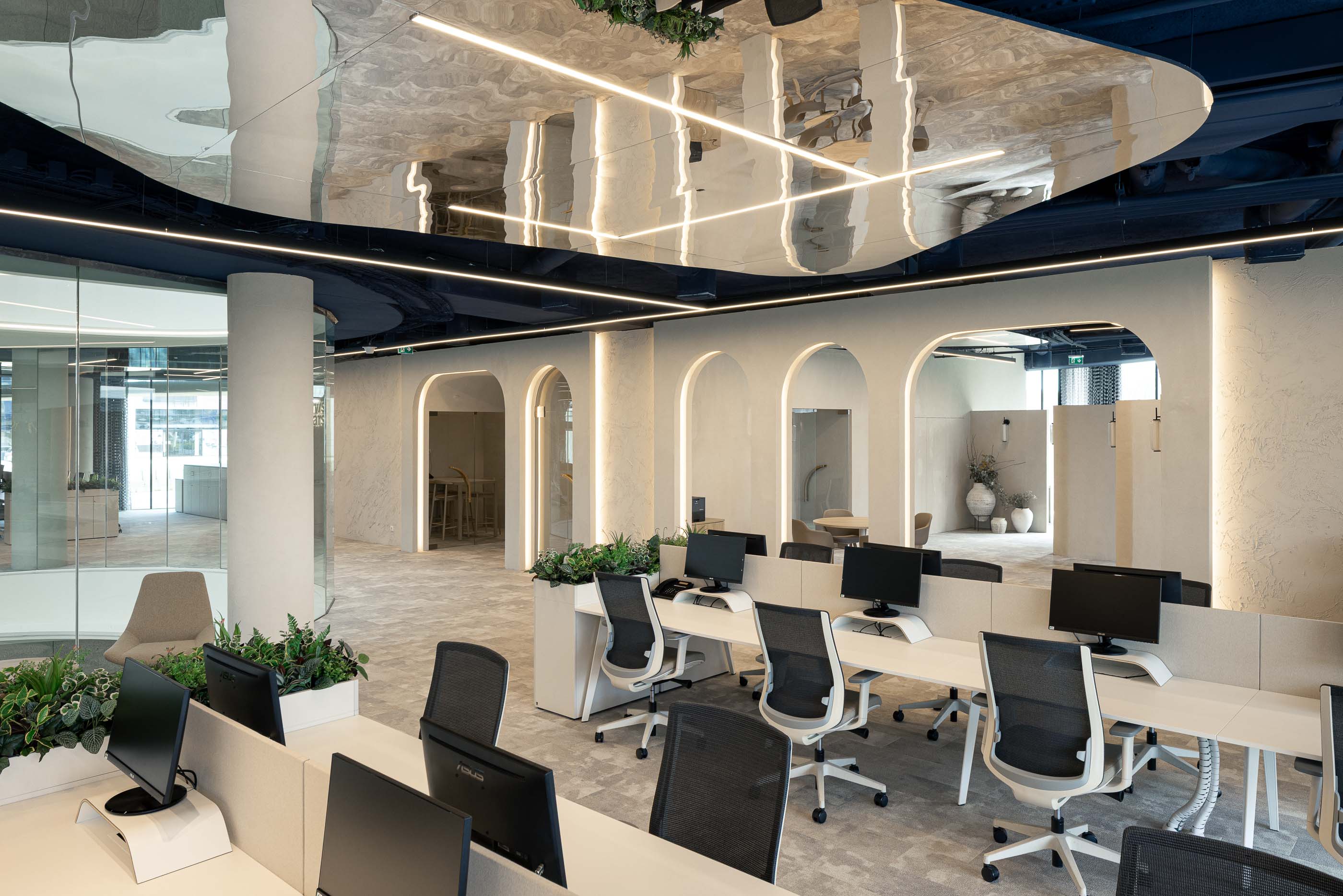Escritório: Open space com secretárias brancas, plantas e vista para o átrio. — Oporto MAZARS offices arquitetura GRAU.ZERO Arquitectura em Porto