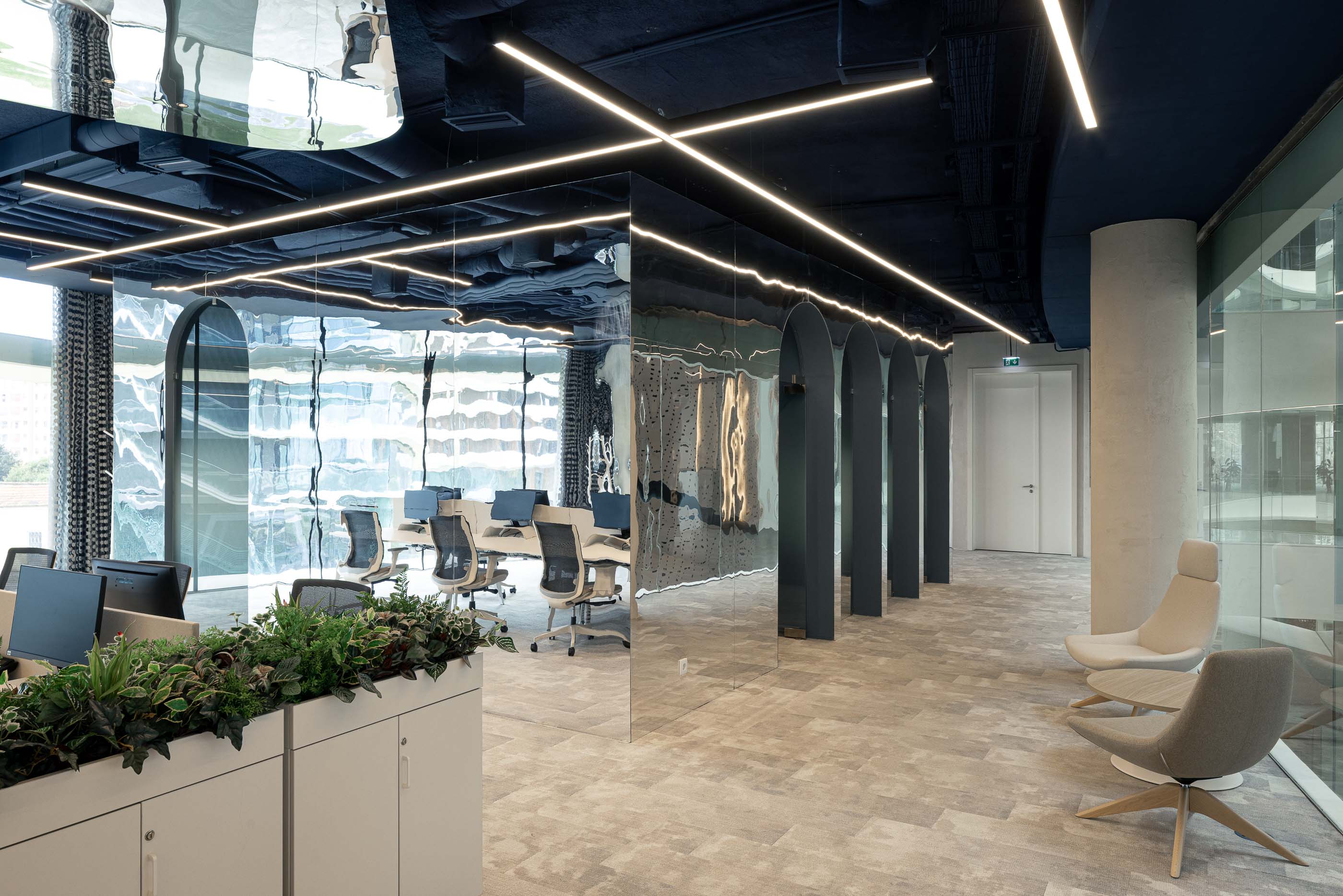 Escritório: Open space com secretárias brancas, cadeiras ergonómicas e divisórias em arco espelhadas. — Oporto MAZARS offices arquitetura GRAU.ZERO Arquitectura em Porto