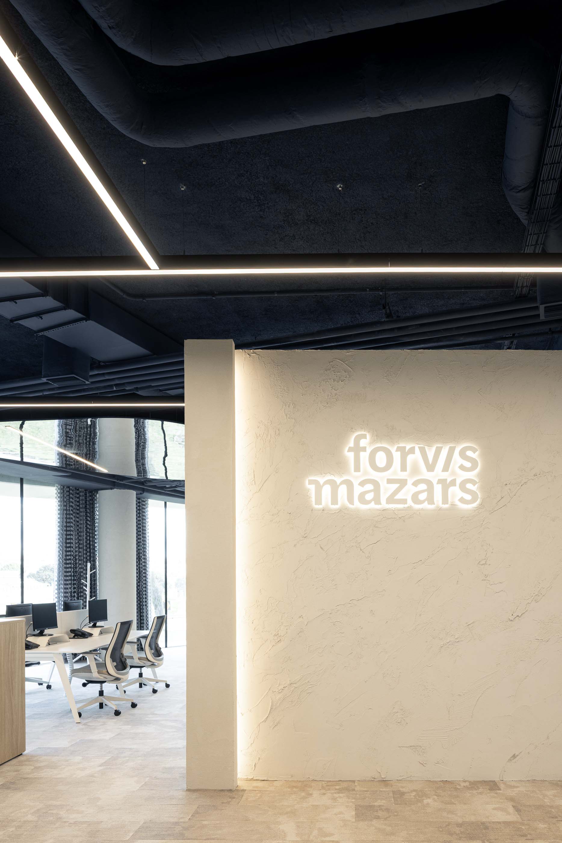 Escritório: Open space com secretárias brancas, cadeiras ergonómicas e alcatifa cinzenta. — Oporto MAZARS offices arquitetura GRAU.ZERO Arquitectura em Porto