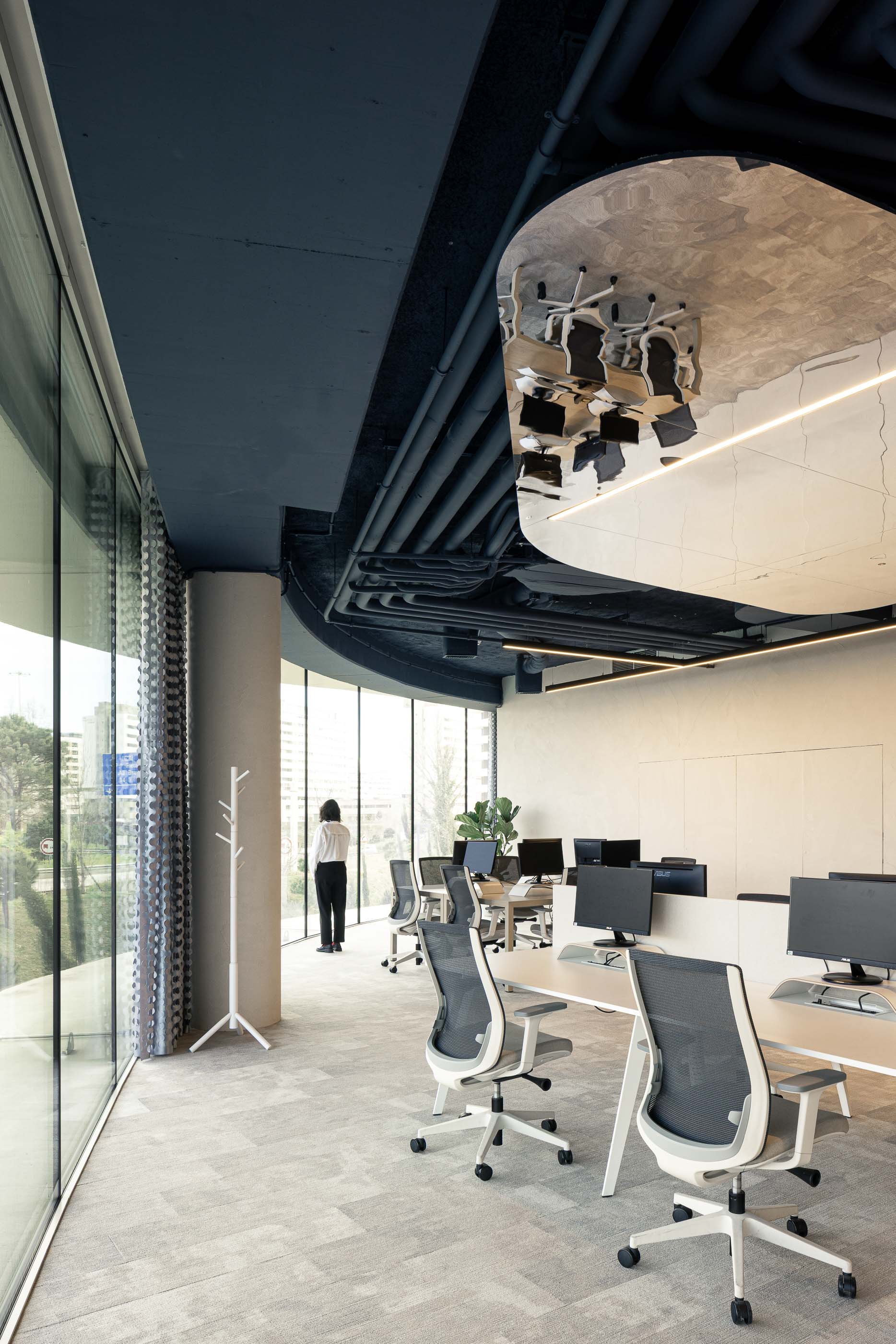 Escritório: Open space com secretárias brancas, cadeiras ergonómicas e vista para a rua. — Oporto MAZARS offices arquitetura GRAU.ZERO Arquitectura em Porto