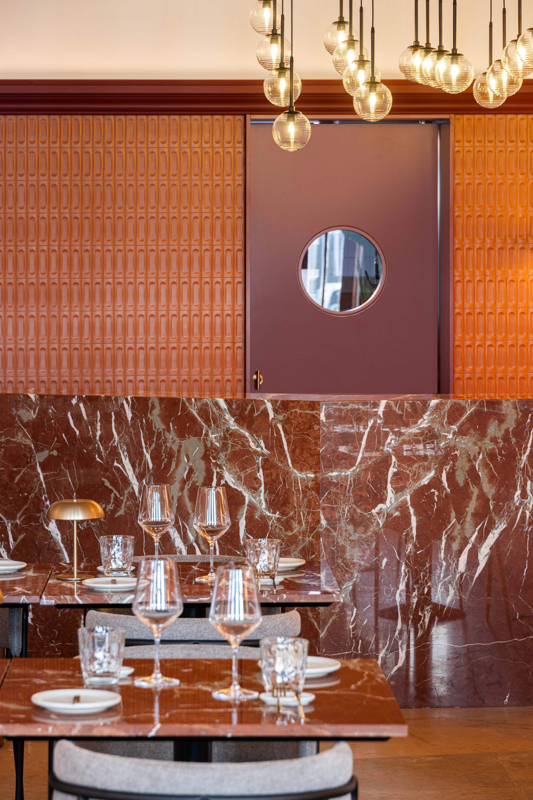 Restaurante: Detalhe do bar com balcão de mármore, parede com revestimento texturado e iluminação suspensa. — Restaurante Concerto arquitetura MiMool Arquitectura & Interiores em vila do conde