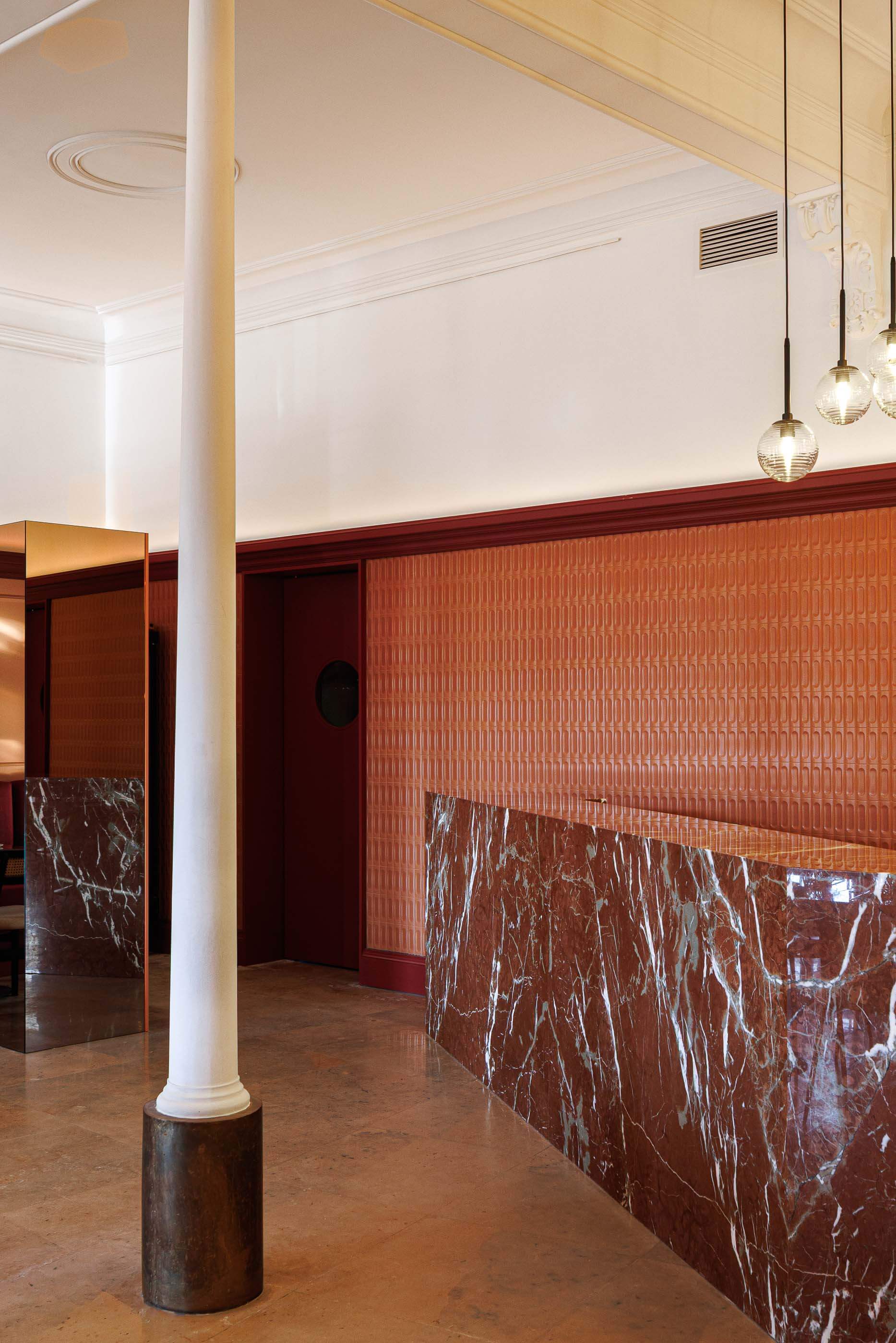 Restaurante: Perspectiva do bar com balcão de mármore, parede texturada e espelho refletindo o salão. — Restaurante Concerto arquitetura MiMool Arquitectura & Interiores em vila do conde